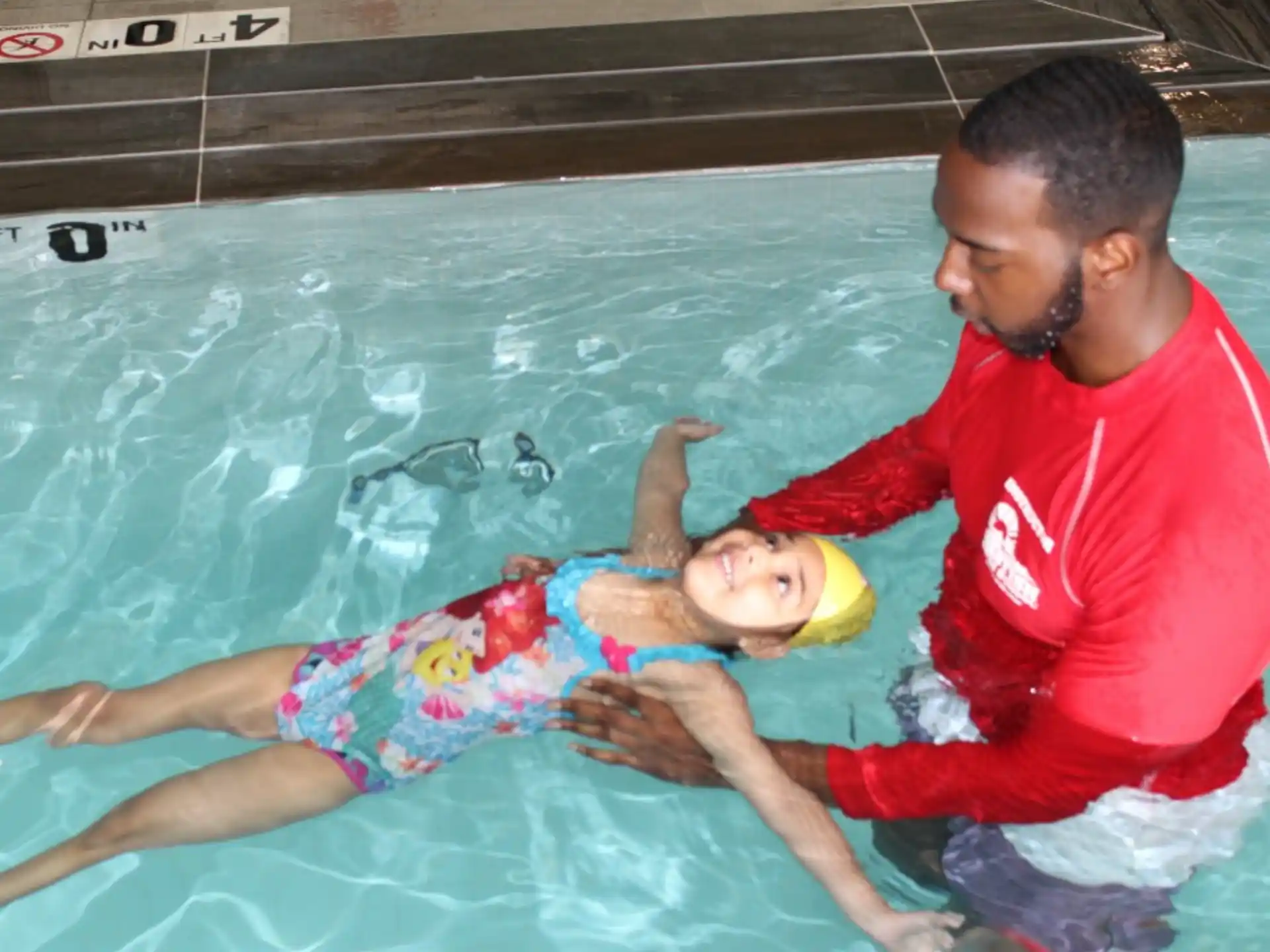 a man holding a baby in a pool