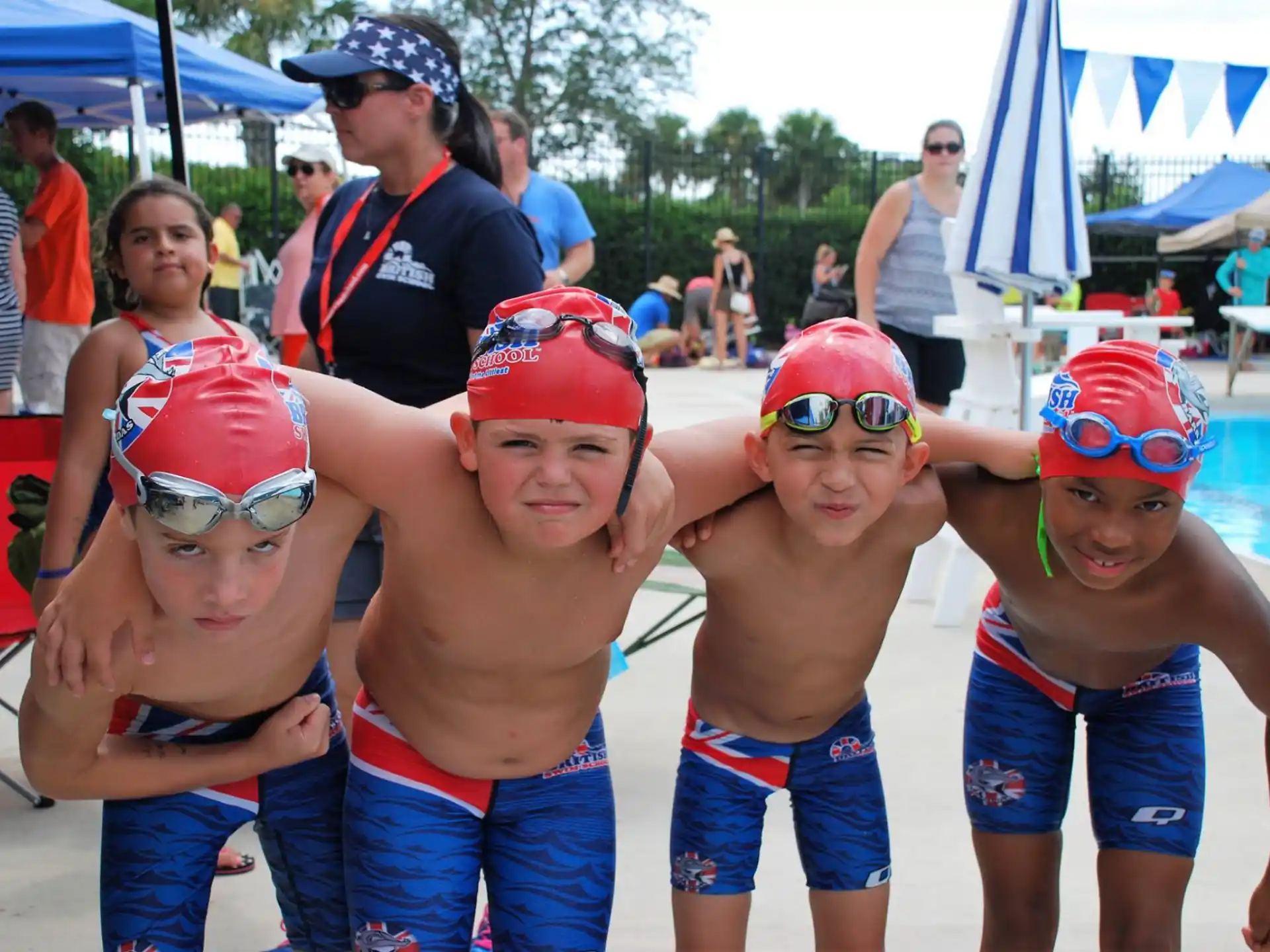 a group of kids wearing swim caps and posing for a photo