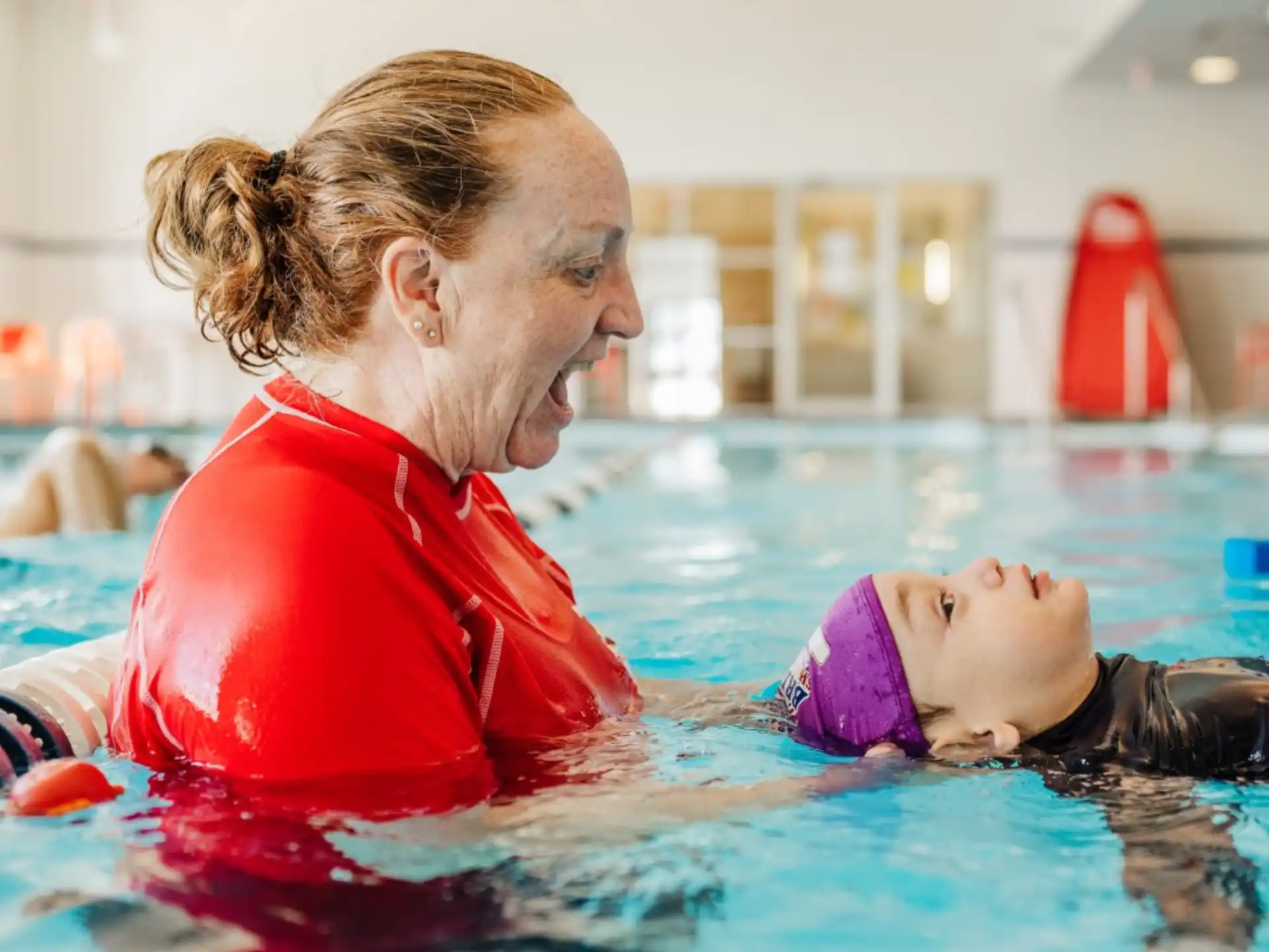 a man holding a baby in a pool