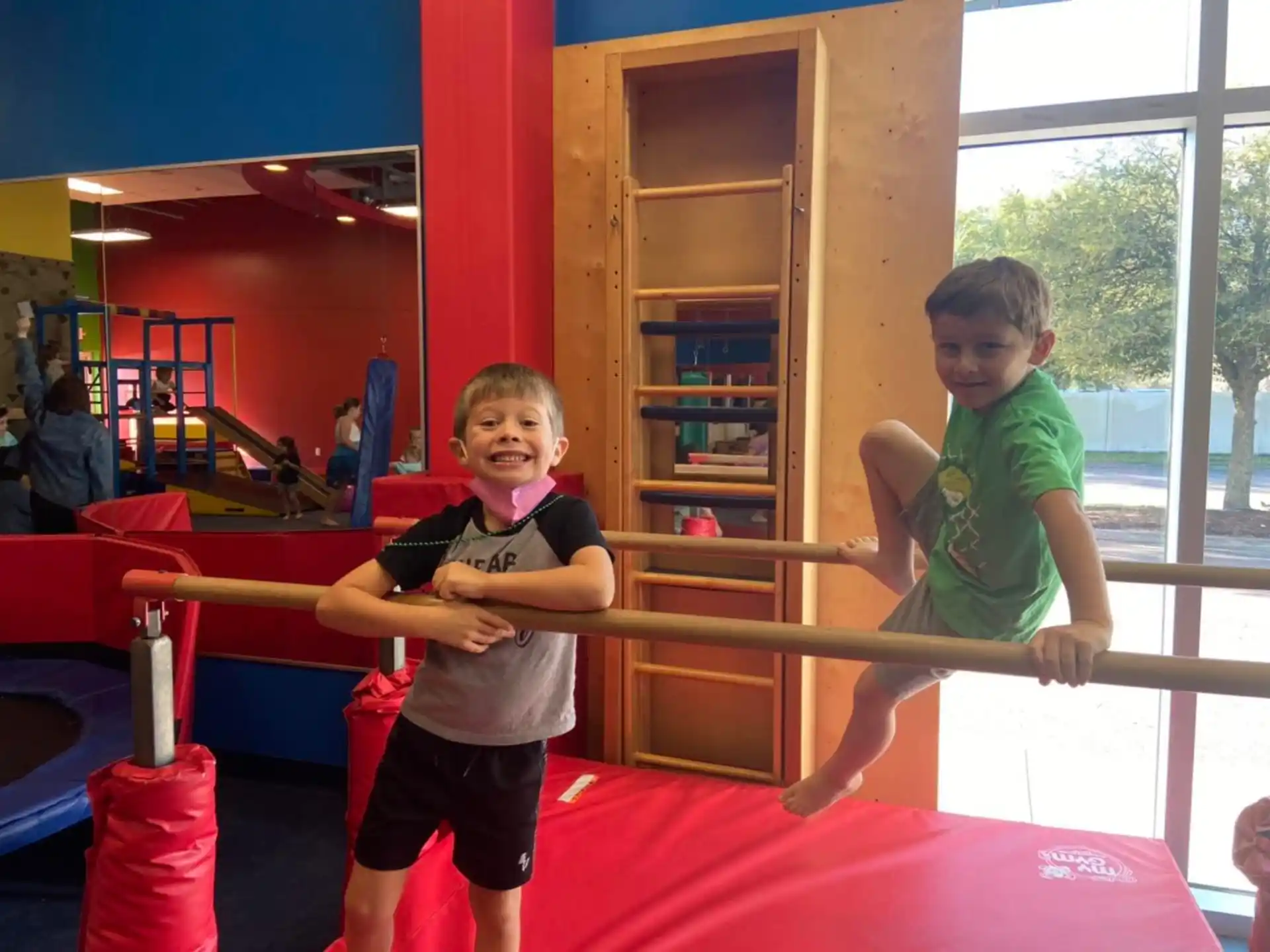 a couple of kids playing on a trampoline