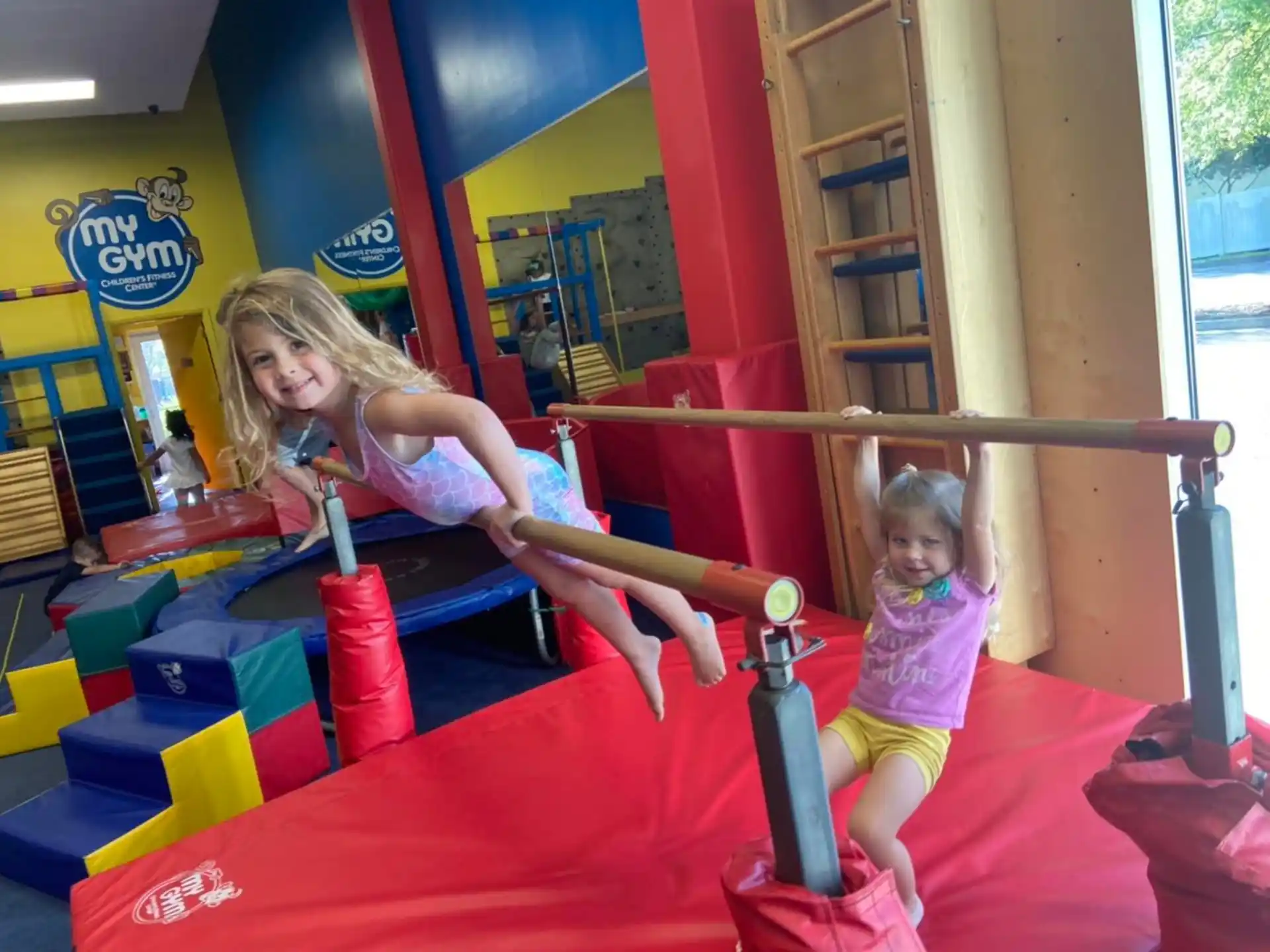 a girl and a baby playing on a toy in a playroom