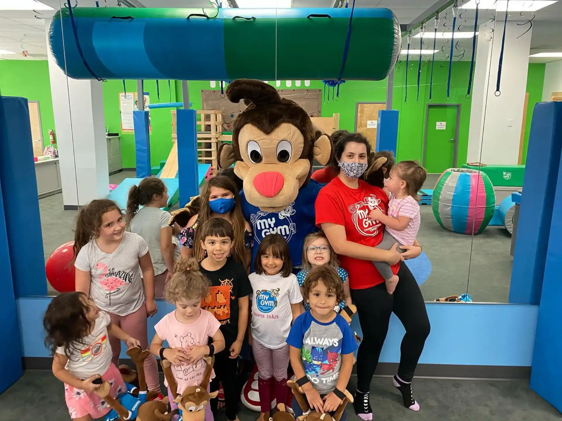 a group of children posing with a person in a garment