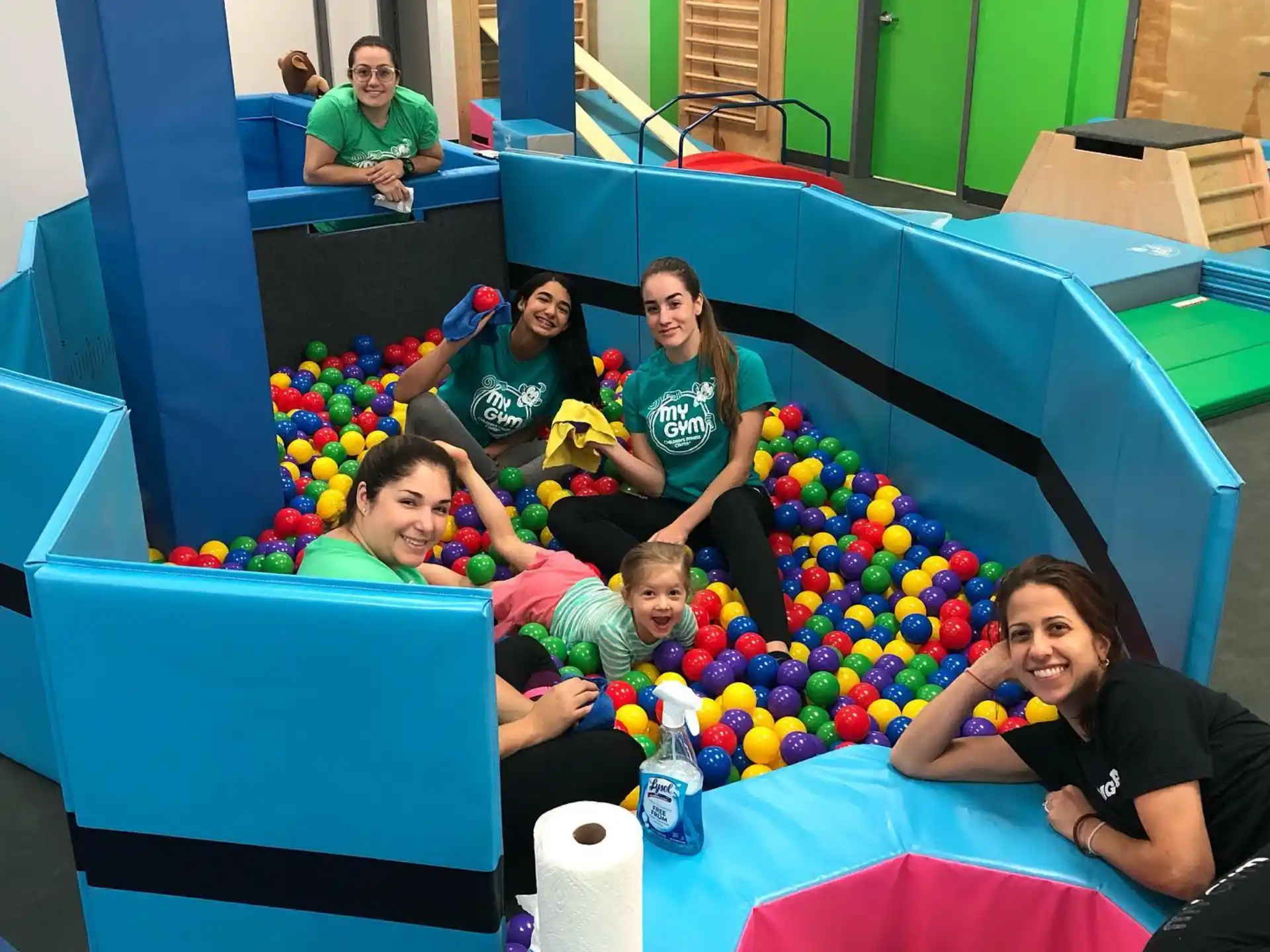 a group of people sitting on a blue and yellow play structure