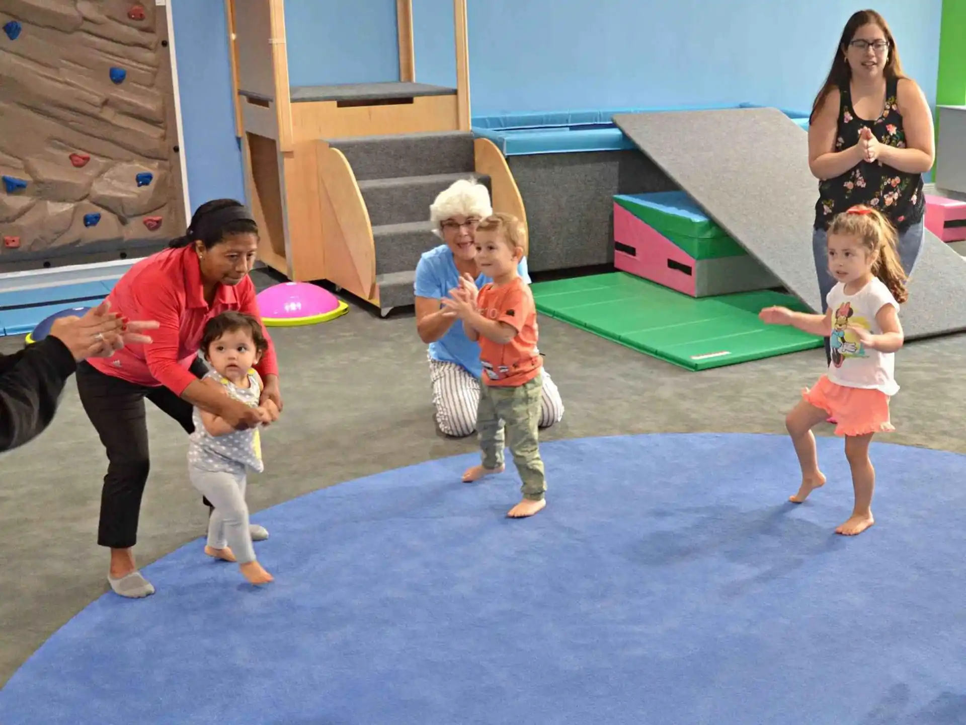 a person and children playing in a room with toys