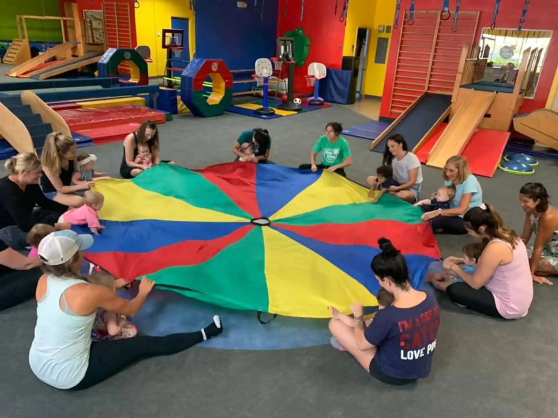 a group of people sitting on the floor with a colorful tent