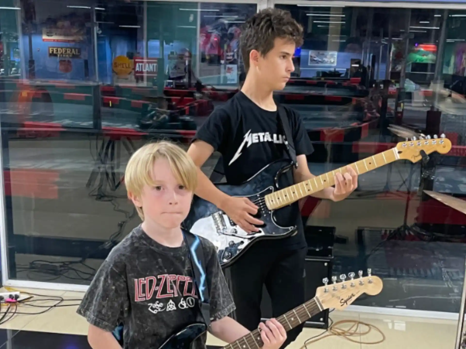 a person and a boy playing guitars