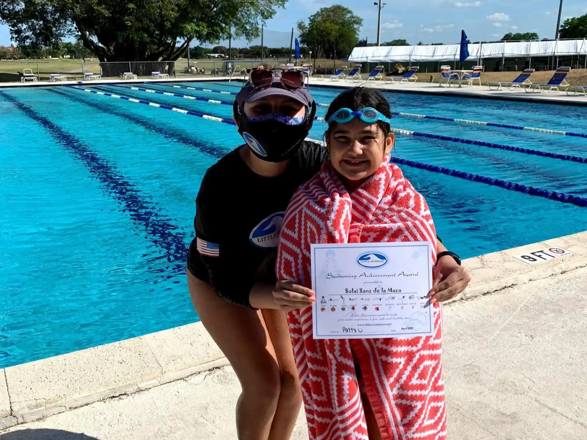a woman and a man posing for a picture next to a pool