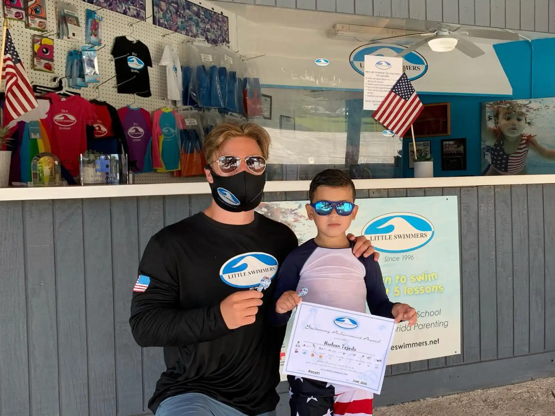 a man and a boy wearing masks and holding a sign