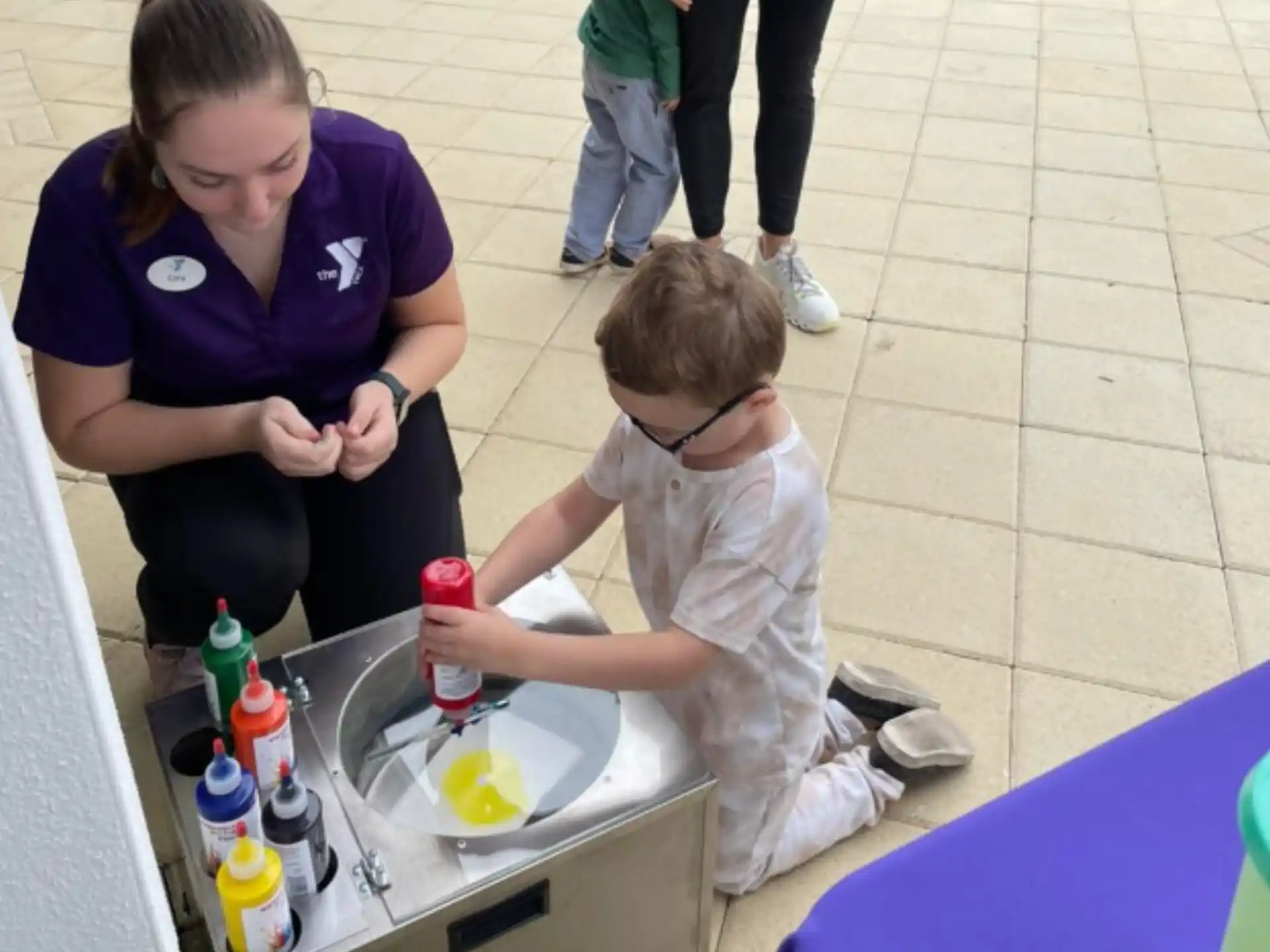 a person and a child sitting at a table with food and drinks