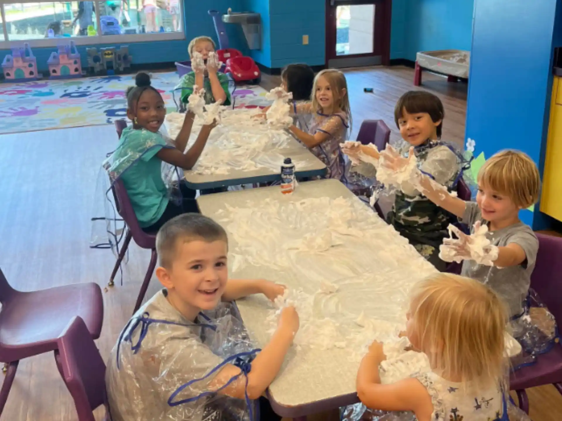 a group of children sitting around a table