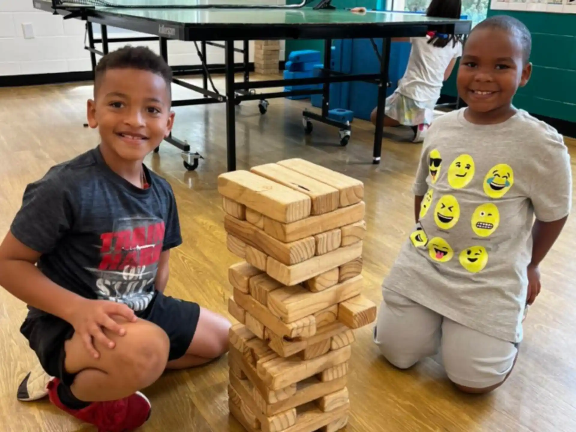 a group of children sitting on the floor with wooden blocks
