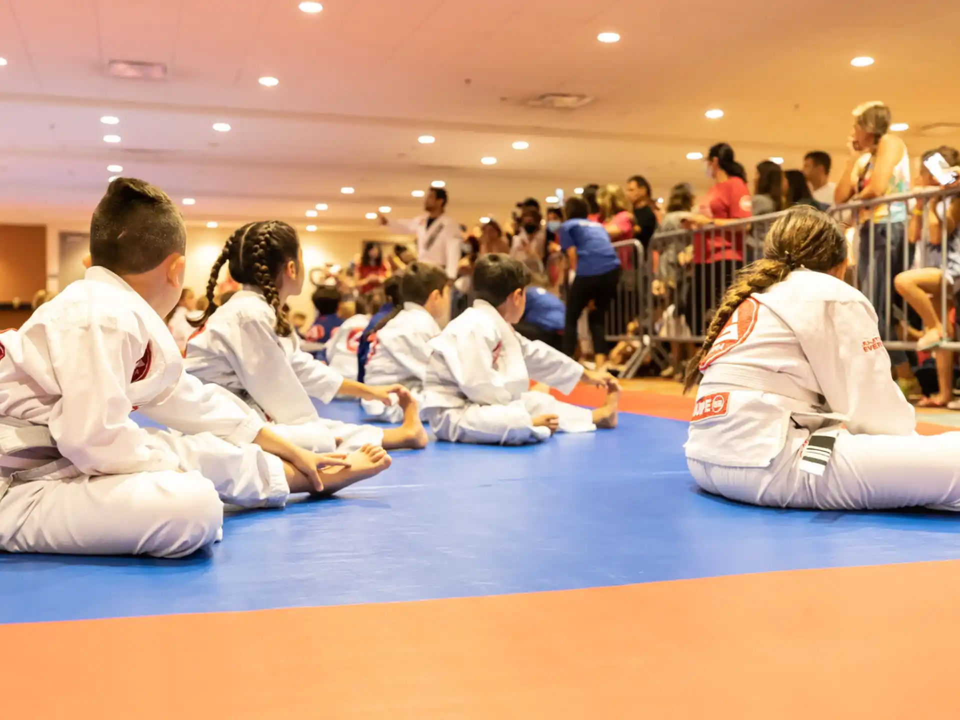 a group of people in white karate uniforms sitting on the floor
