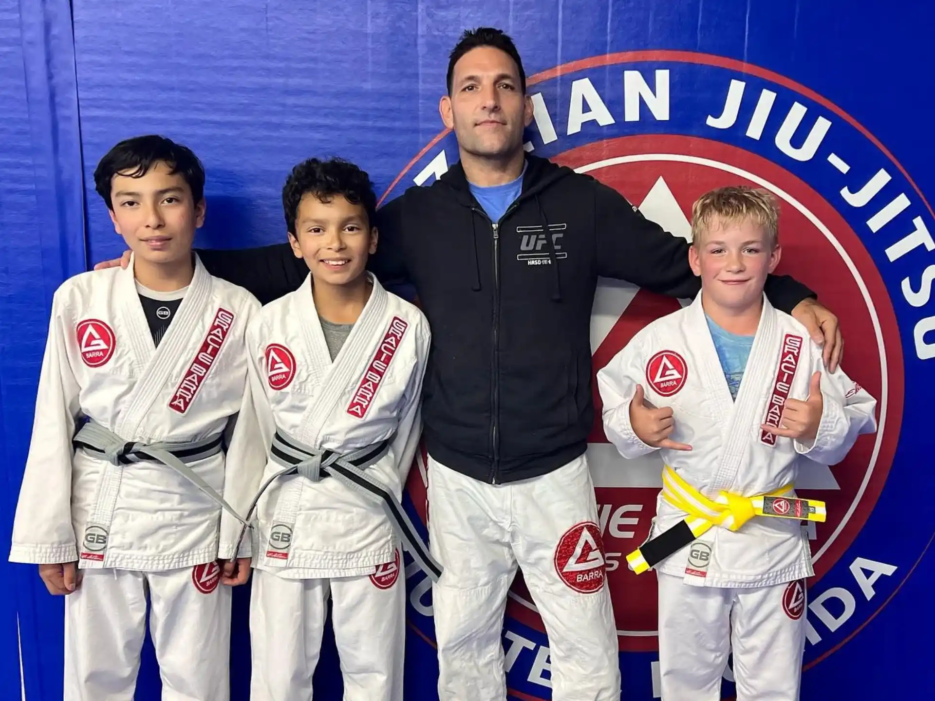 a man standing with a group of boys in karate uniforms
