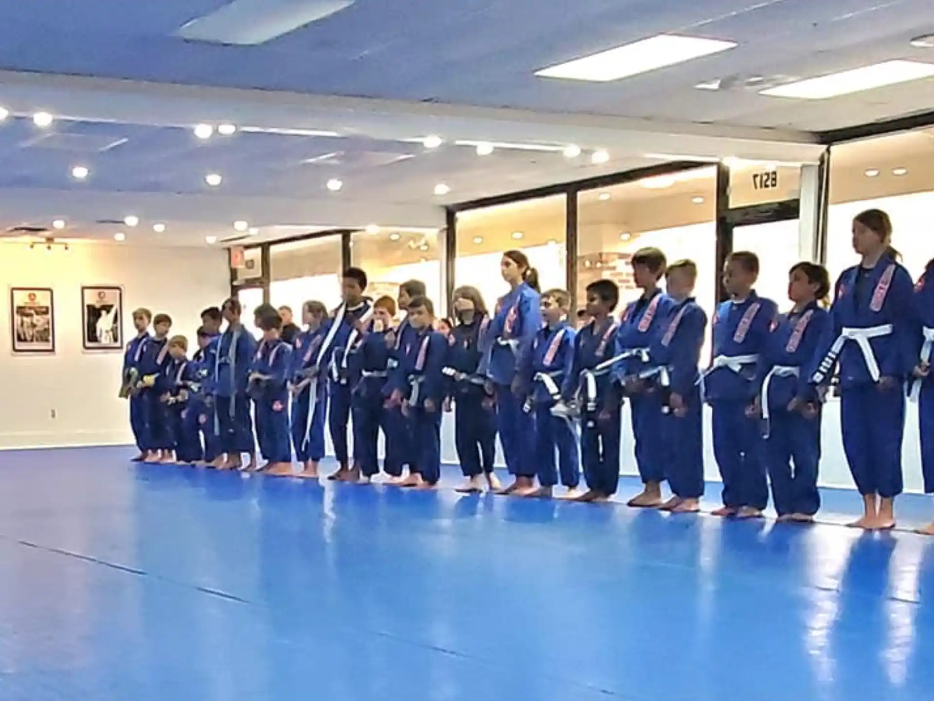 a group of people in blue karate uniforms standing in a room