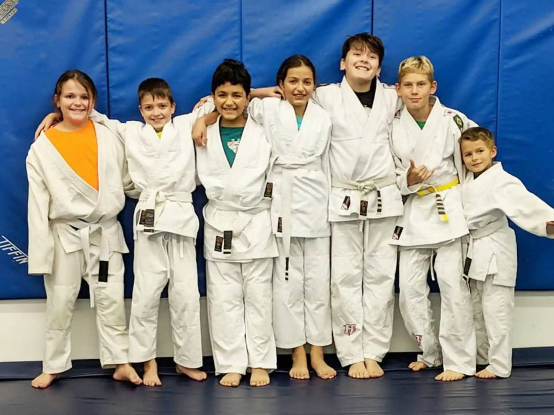 a group of people in white karate uniforms