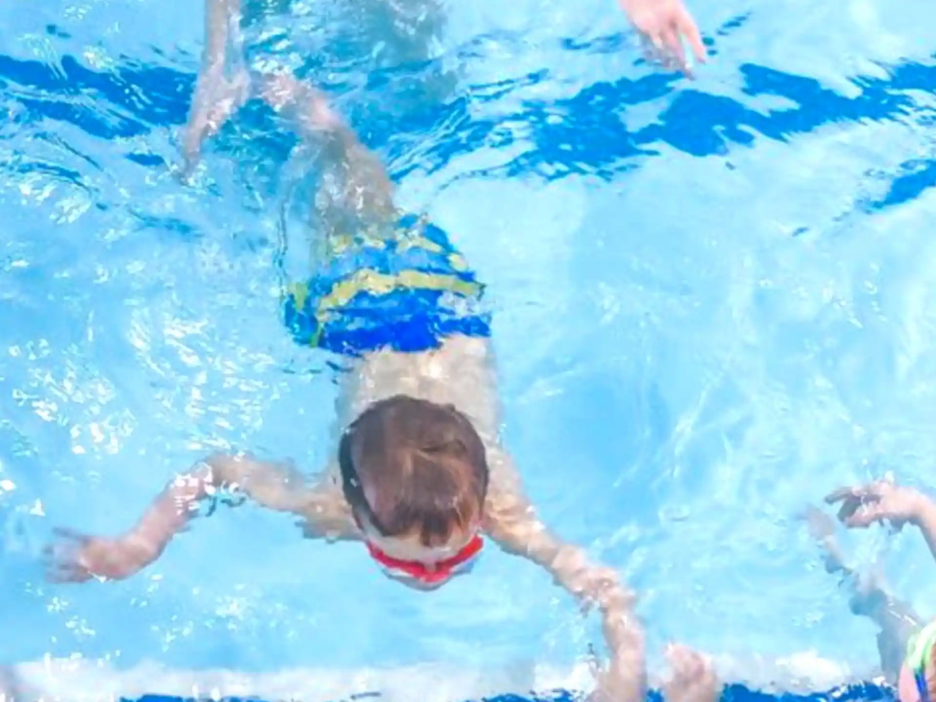 a boy swimming in a pool