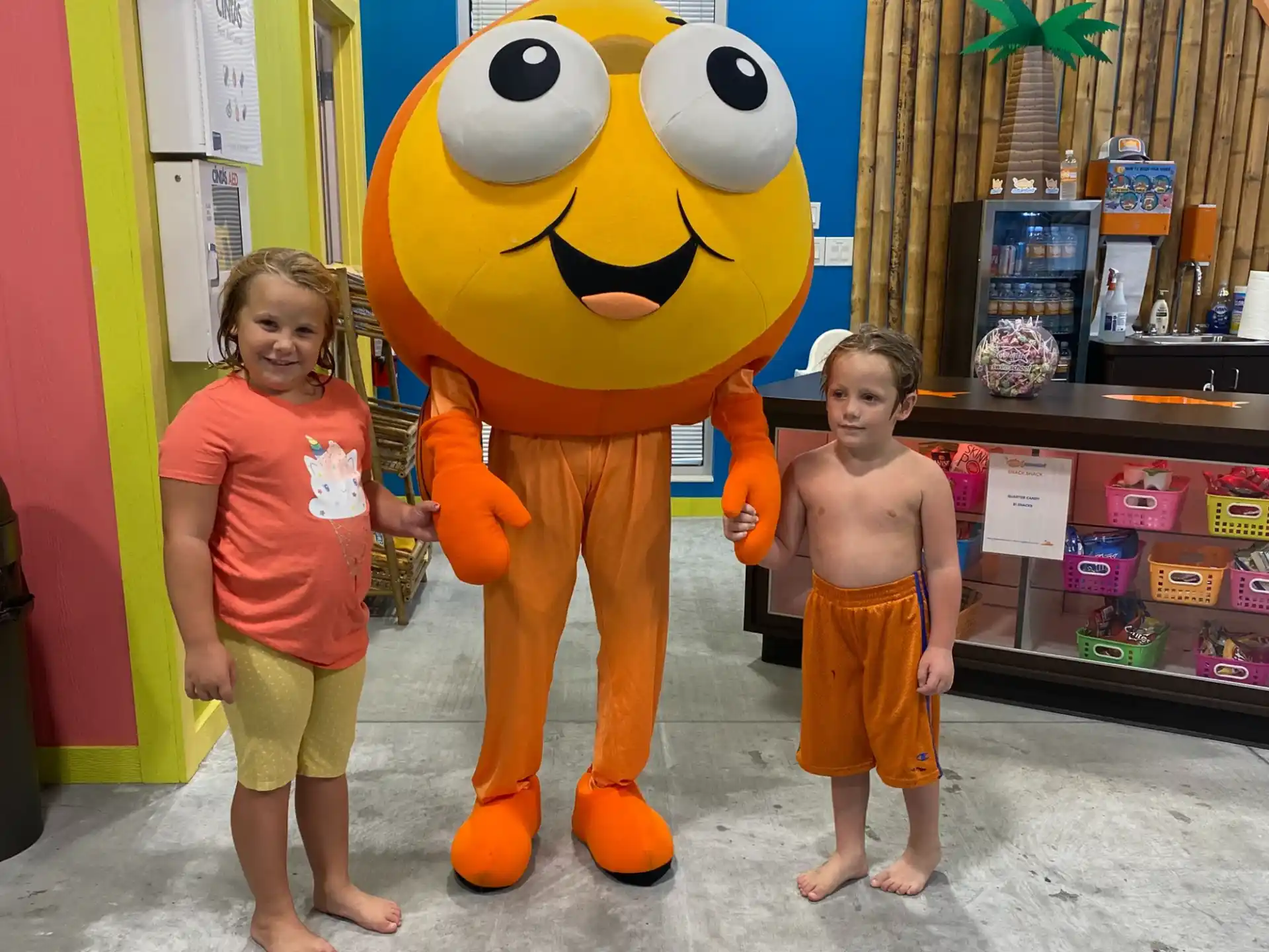 a couple of children posing with a person in a garment