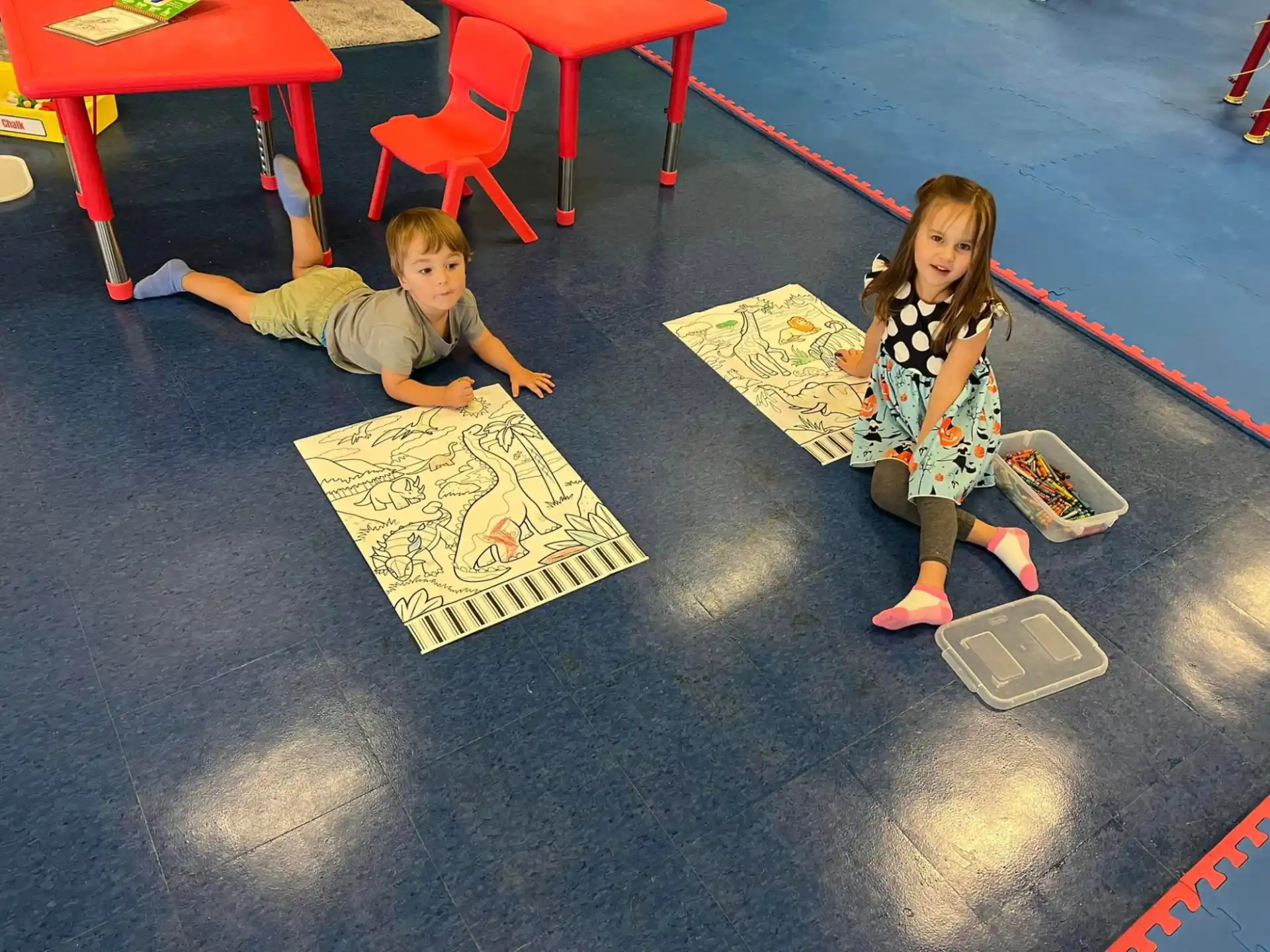 a boy and girl playing on the floor