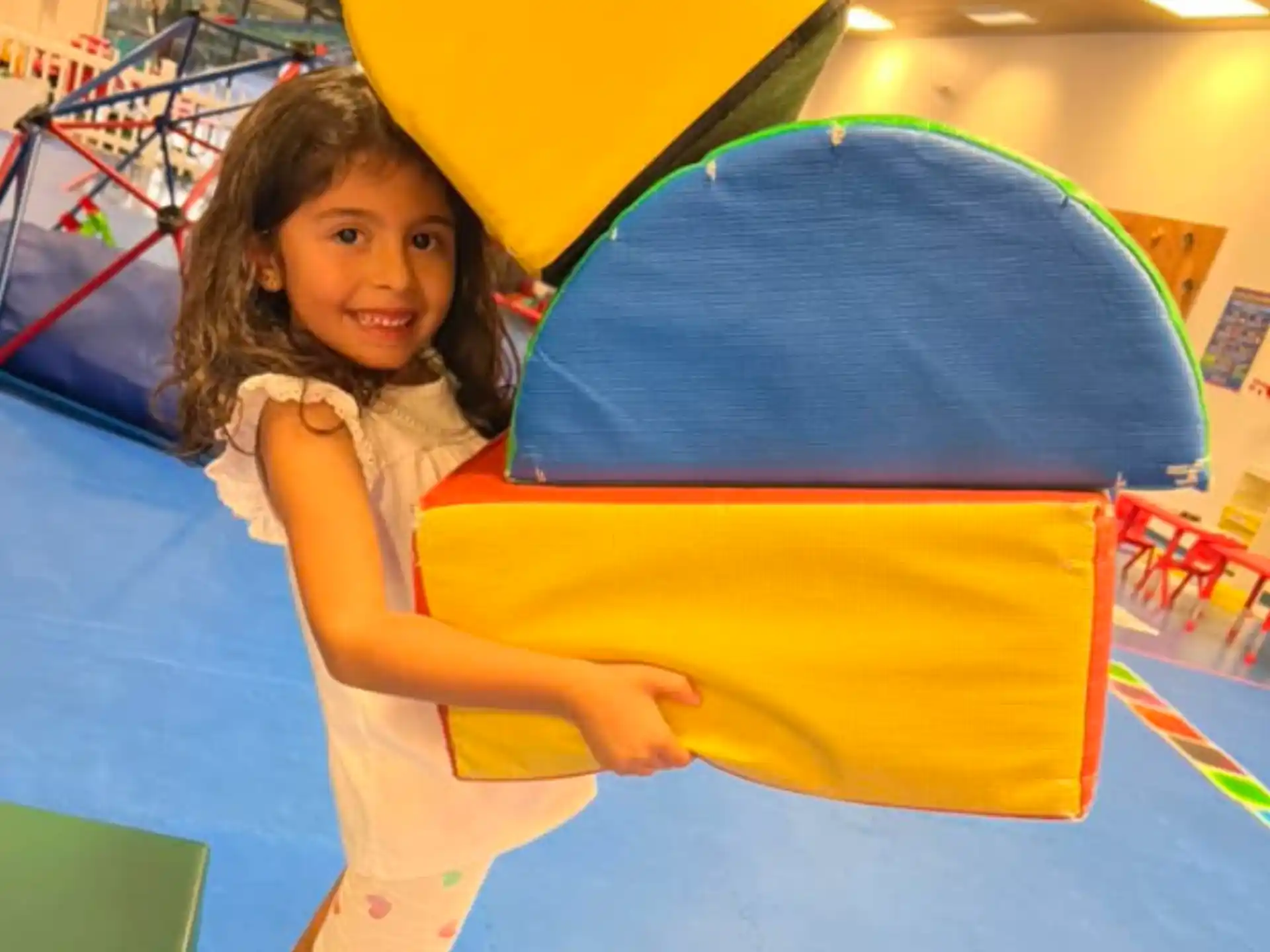 a girl holding a large yellow and blue object