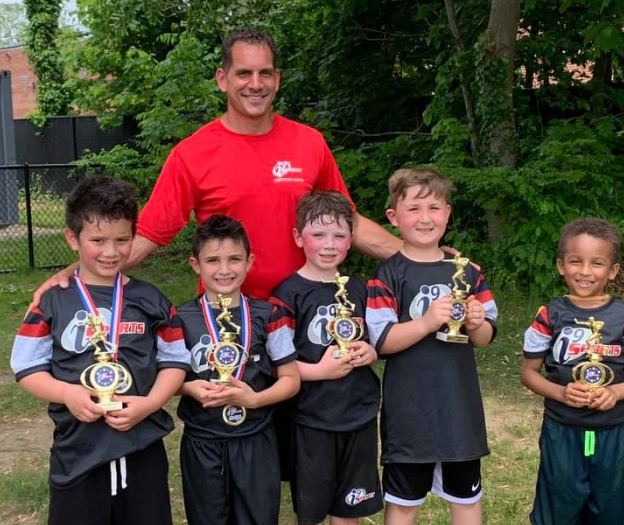 a group of boys posing for a picture with a trophy