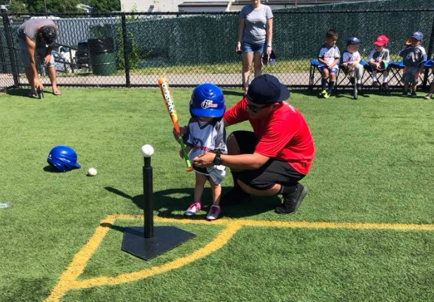 a person and a boy playing baseball