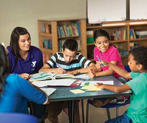 a group of children sitting at a table in a library