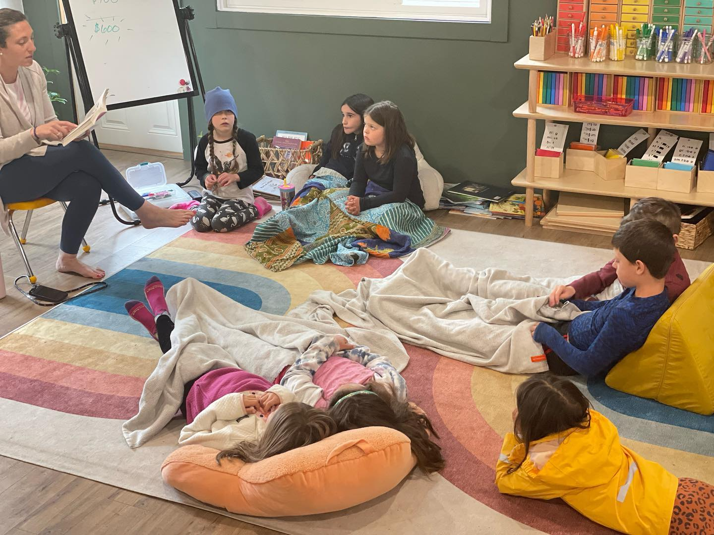 a group of children sitting on the floor in a classroom