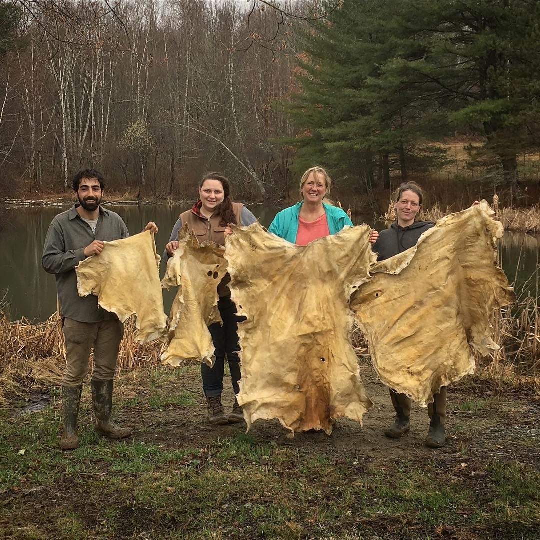 a group of people holding large bales of hay