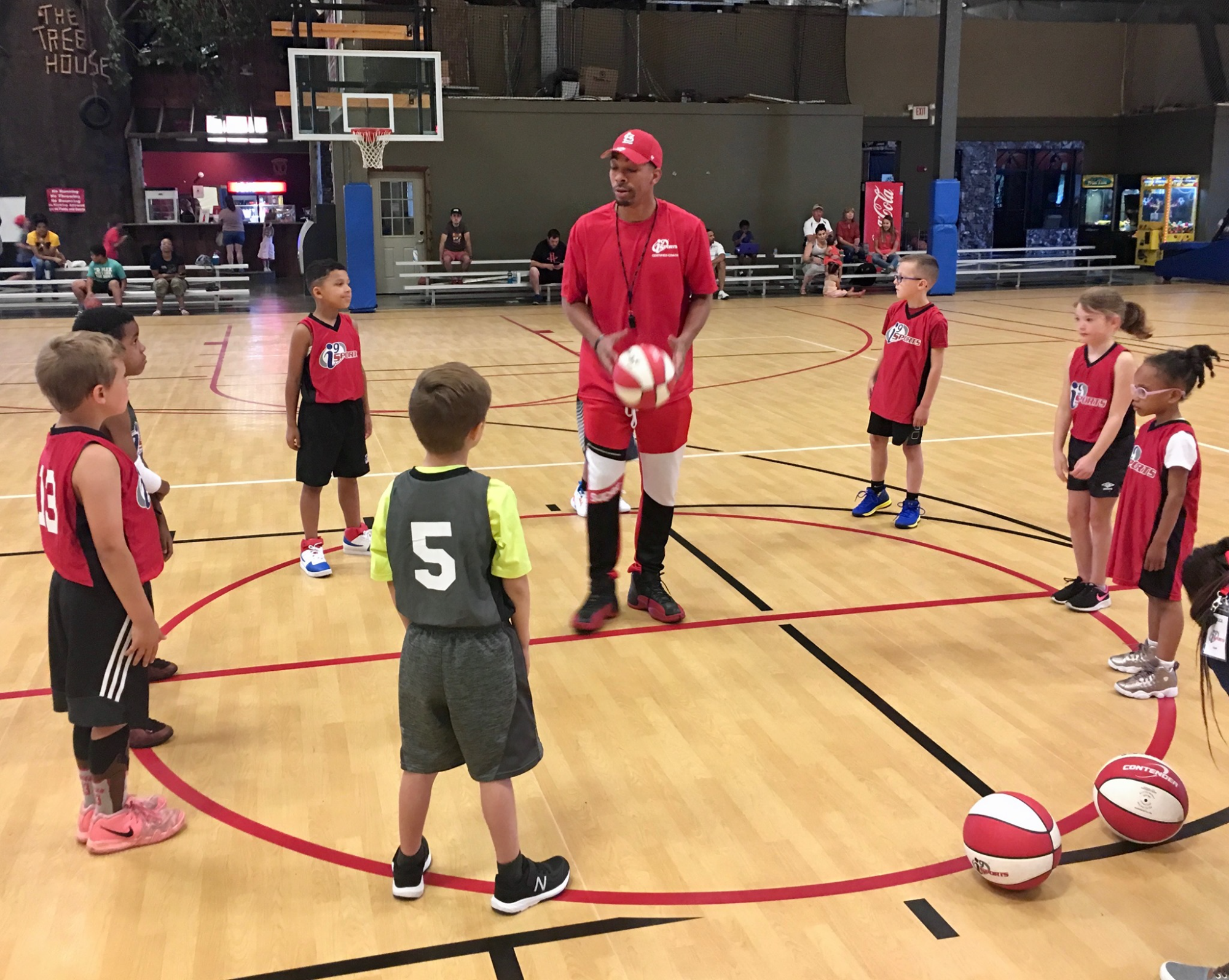 a person standing in front of a group of kids playing football