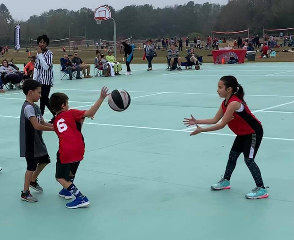 a group of kids playing basketball