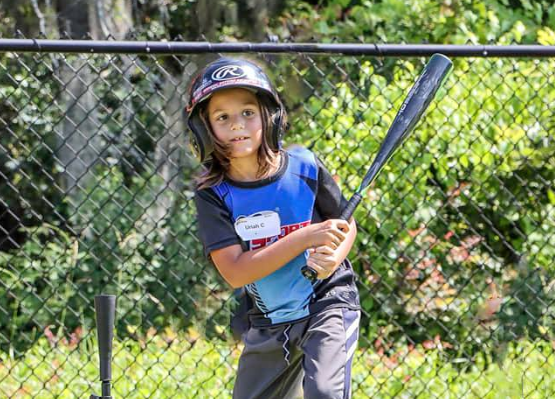 a young girl holding a baseball bat