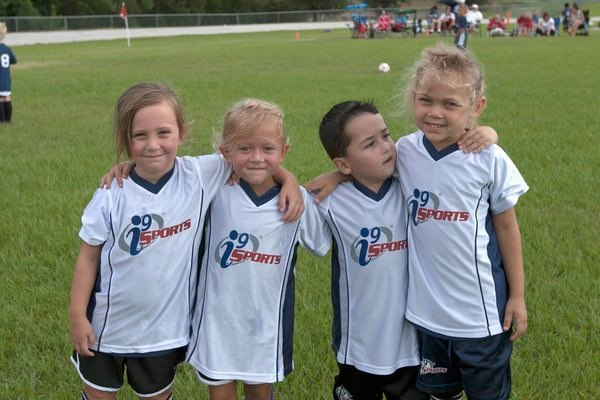 a group of children posing for a photo on a field