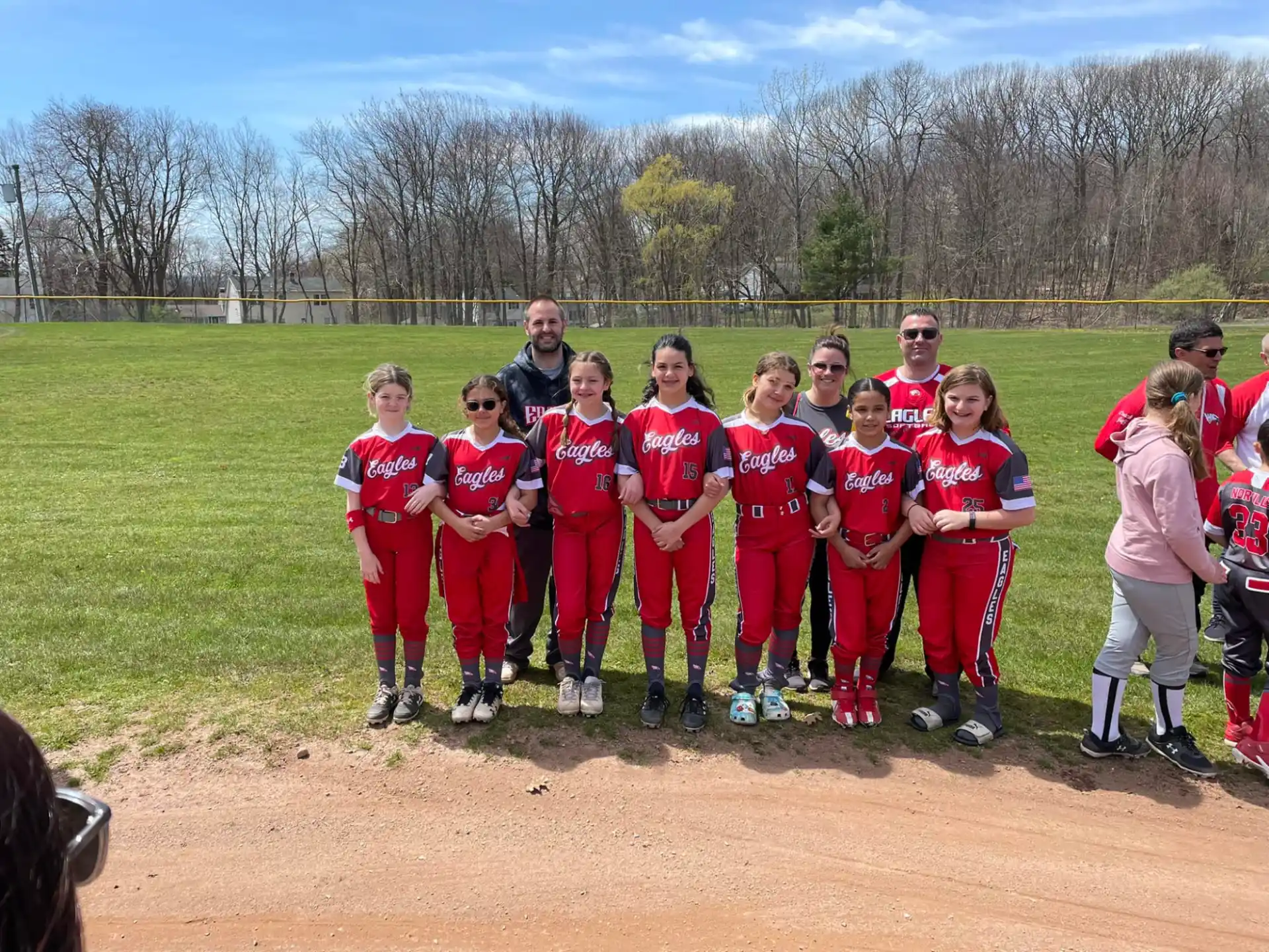 a group of kids in red uniforms standing on a field