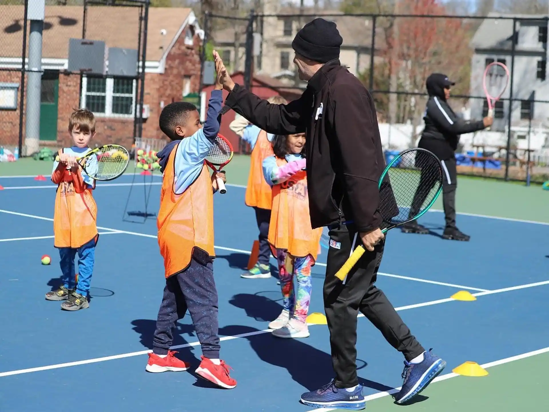 a person and kids playing tennis
