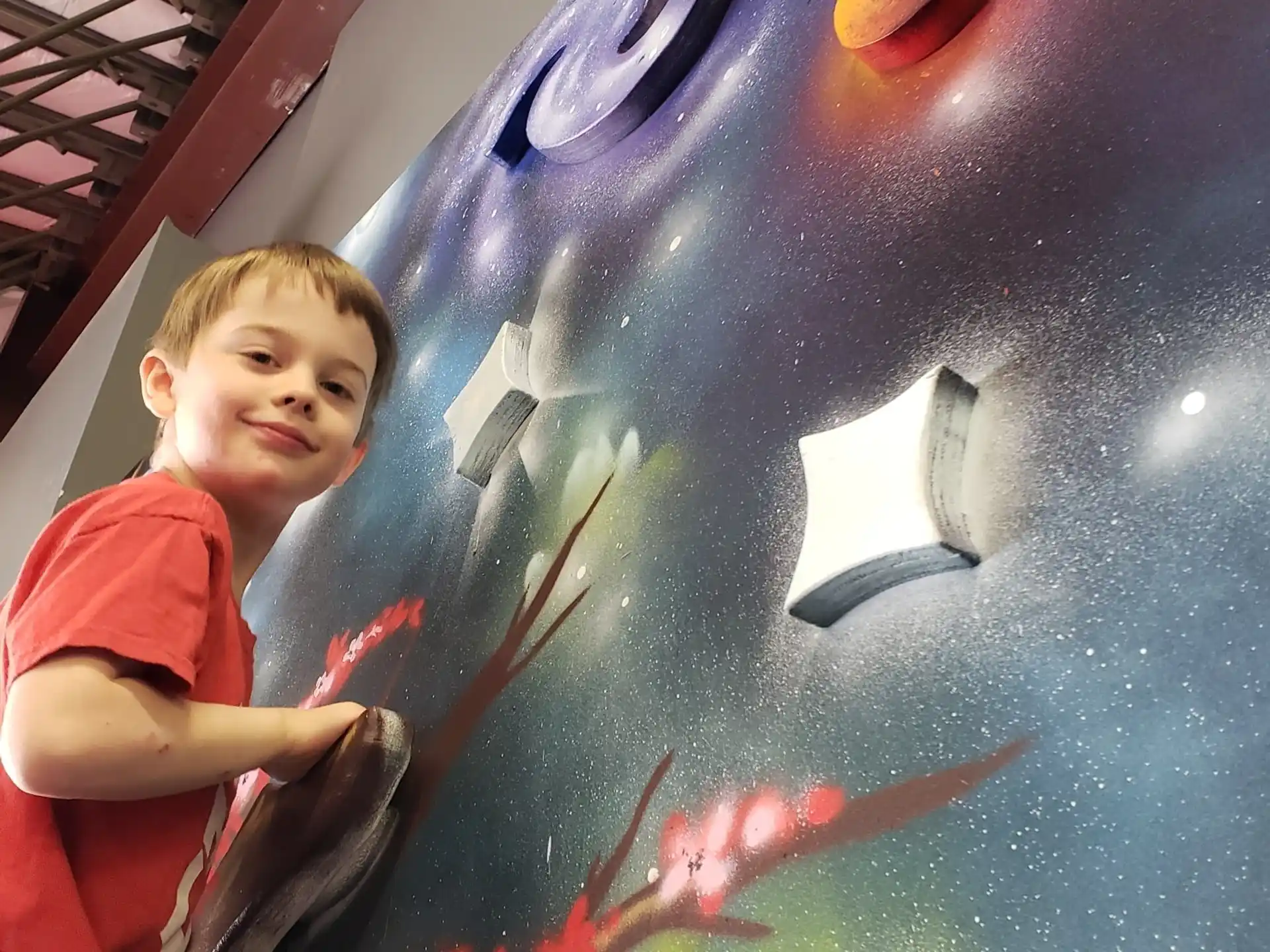 a boy standing next to a large blue ball