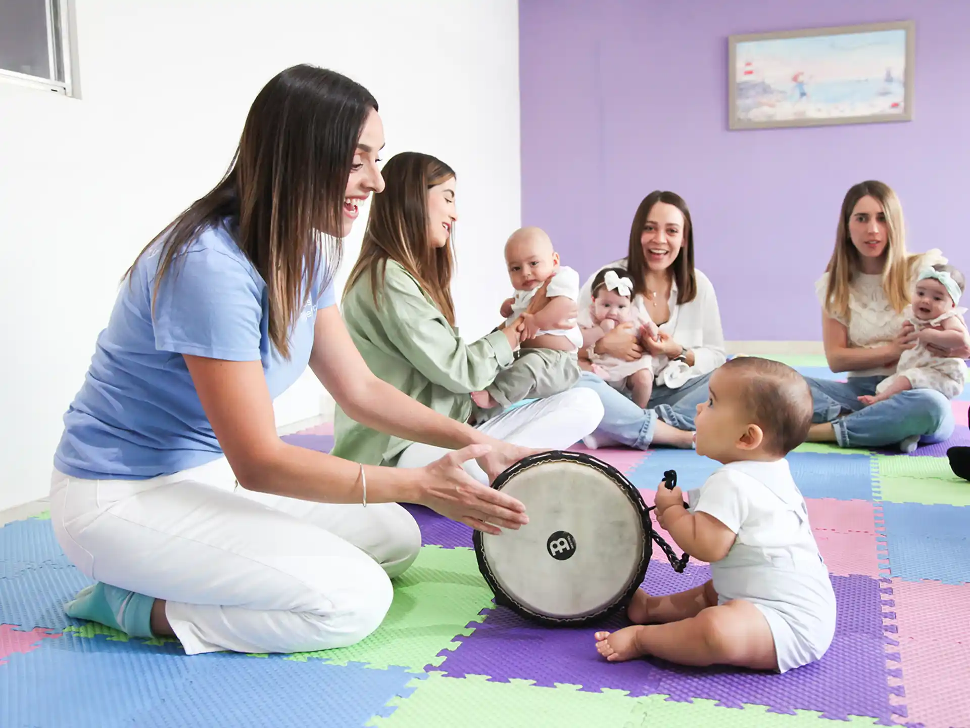 a woman kneeling down to pet a baby