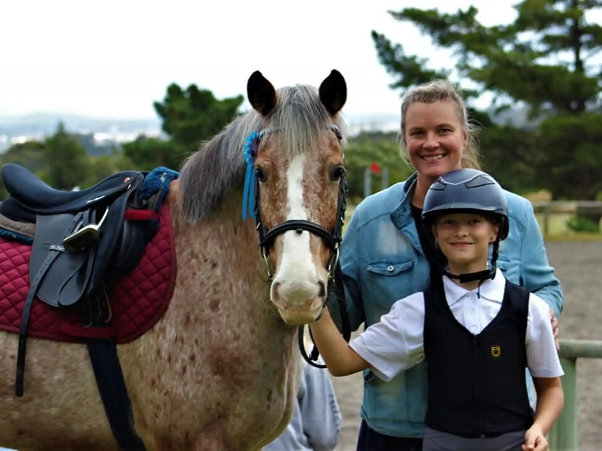 a person and a child posing with a horse