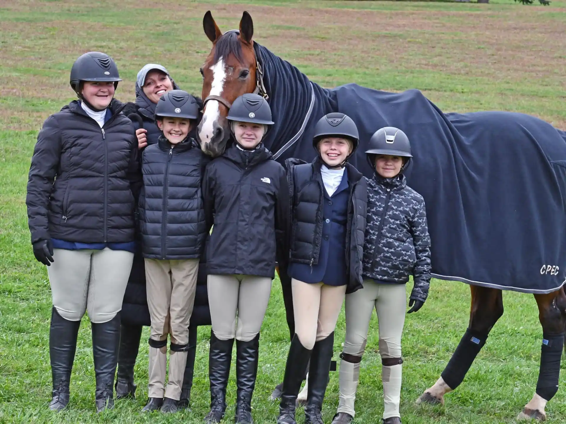 a group of people posing for a photo with a horse