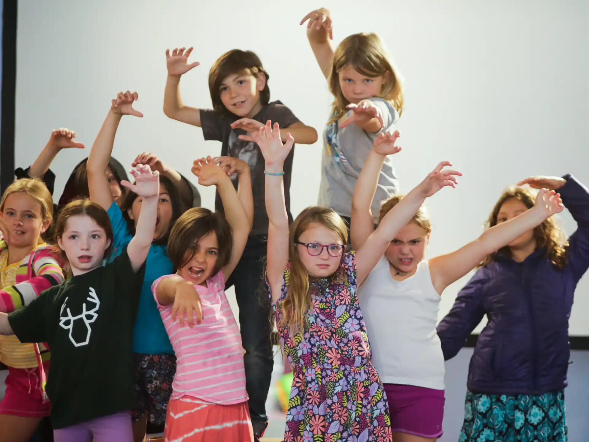 a group of children raising their hands