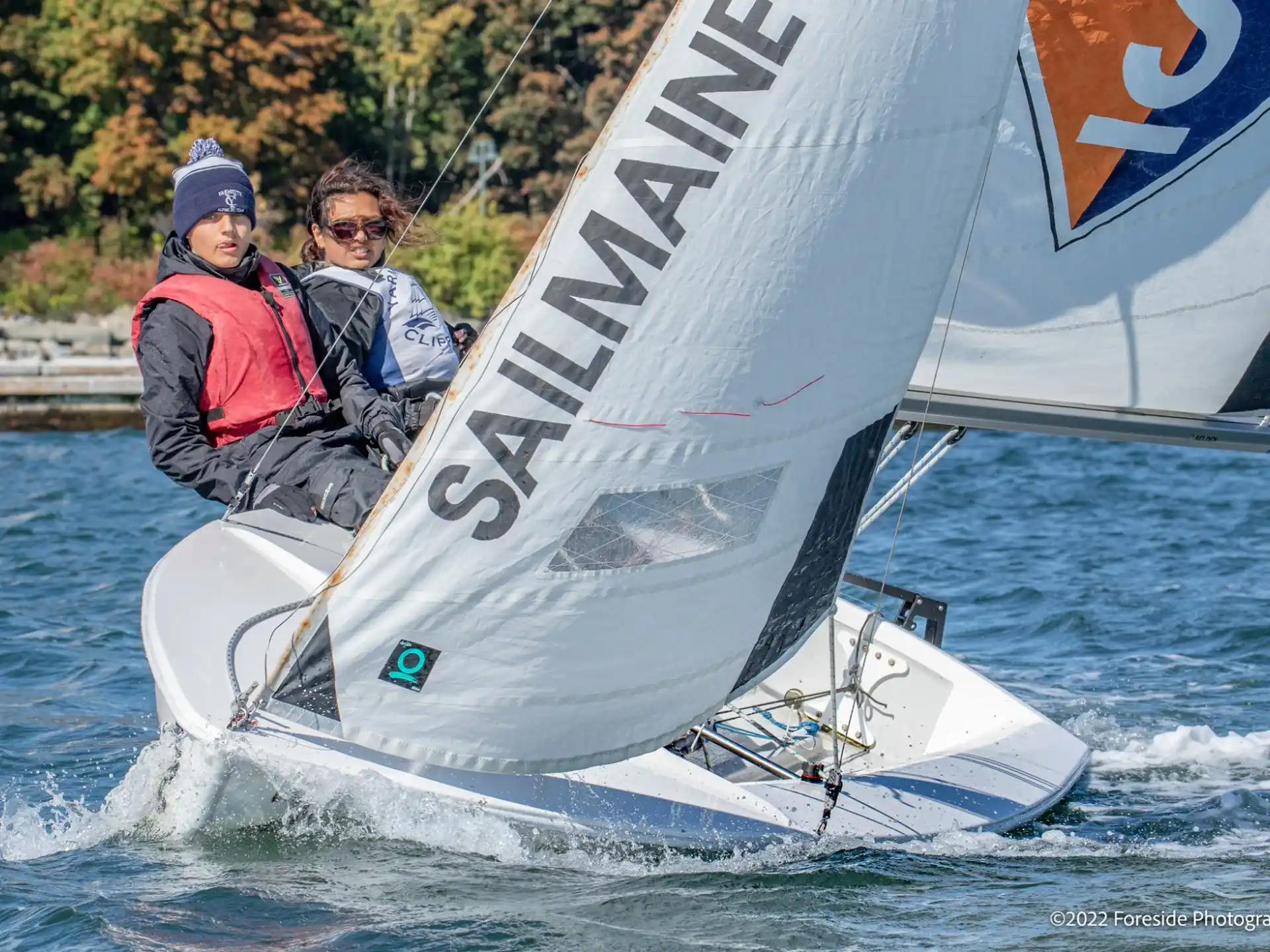 a couple of people on a sailboat on water