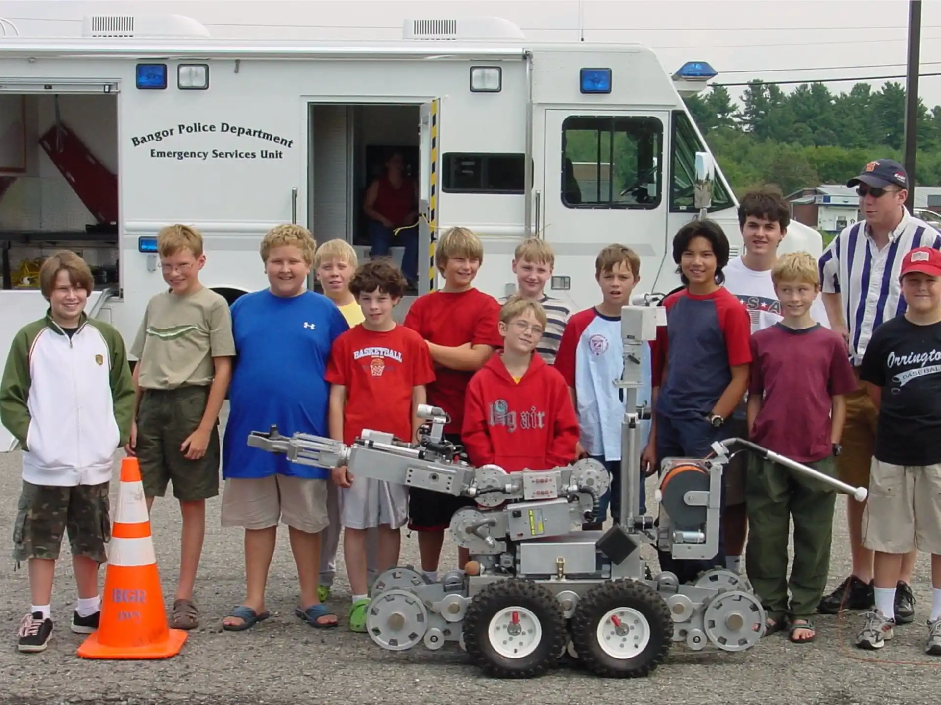 a group of kids posing for a photo in front of a camper