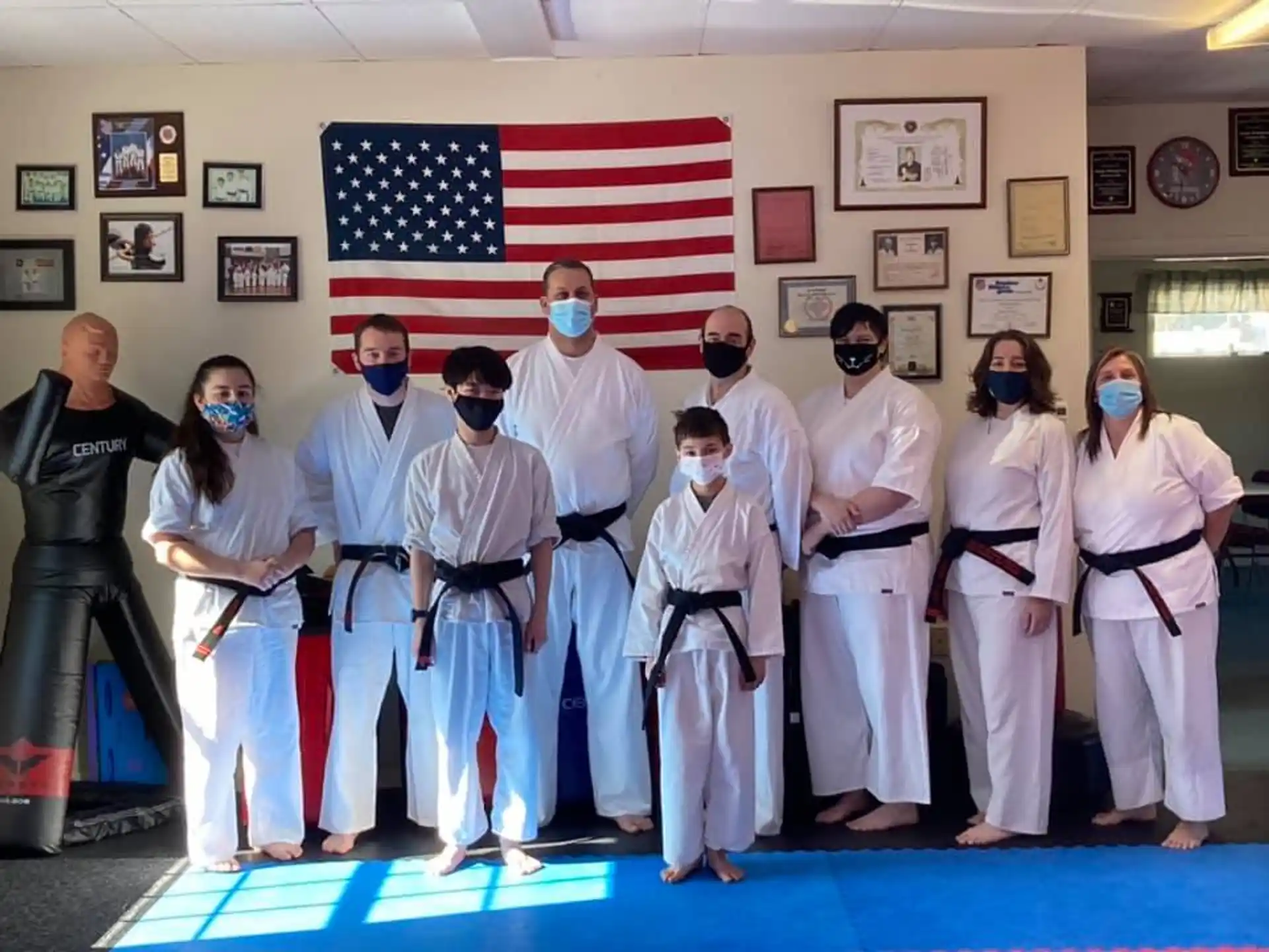 a group of people in white karate uniforms posing for a photo