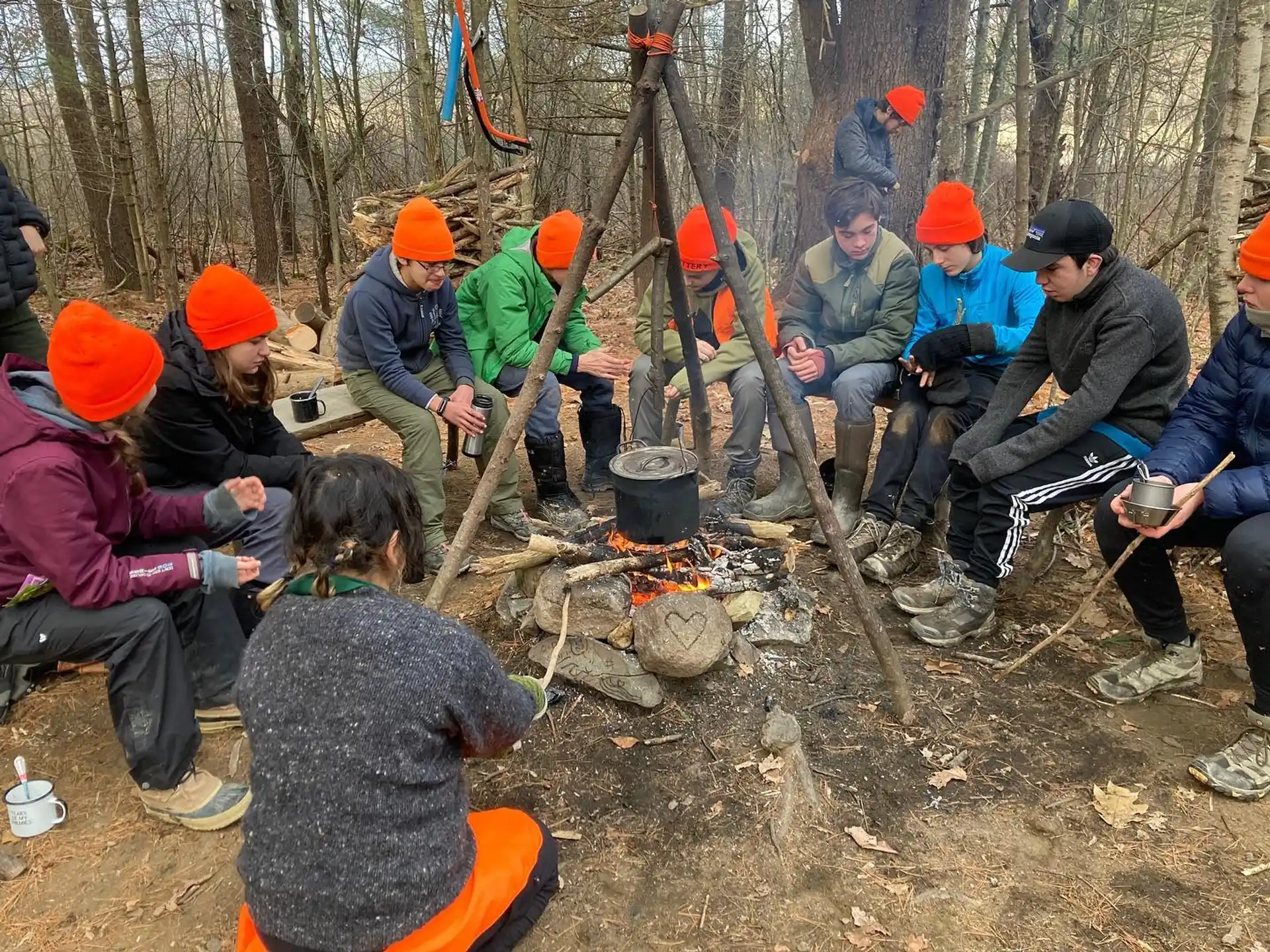 a group of people sitting on the ground with a fire