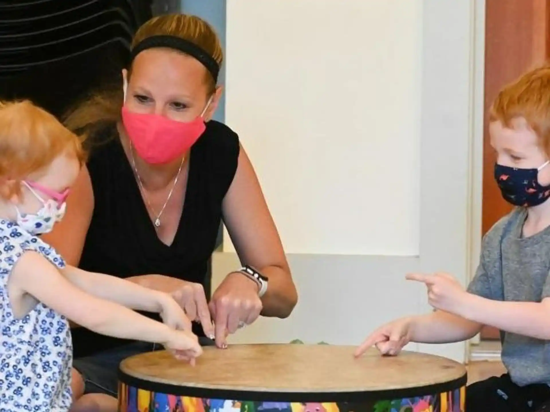 a person and two children wearing face masks