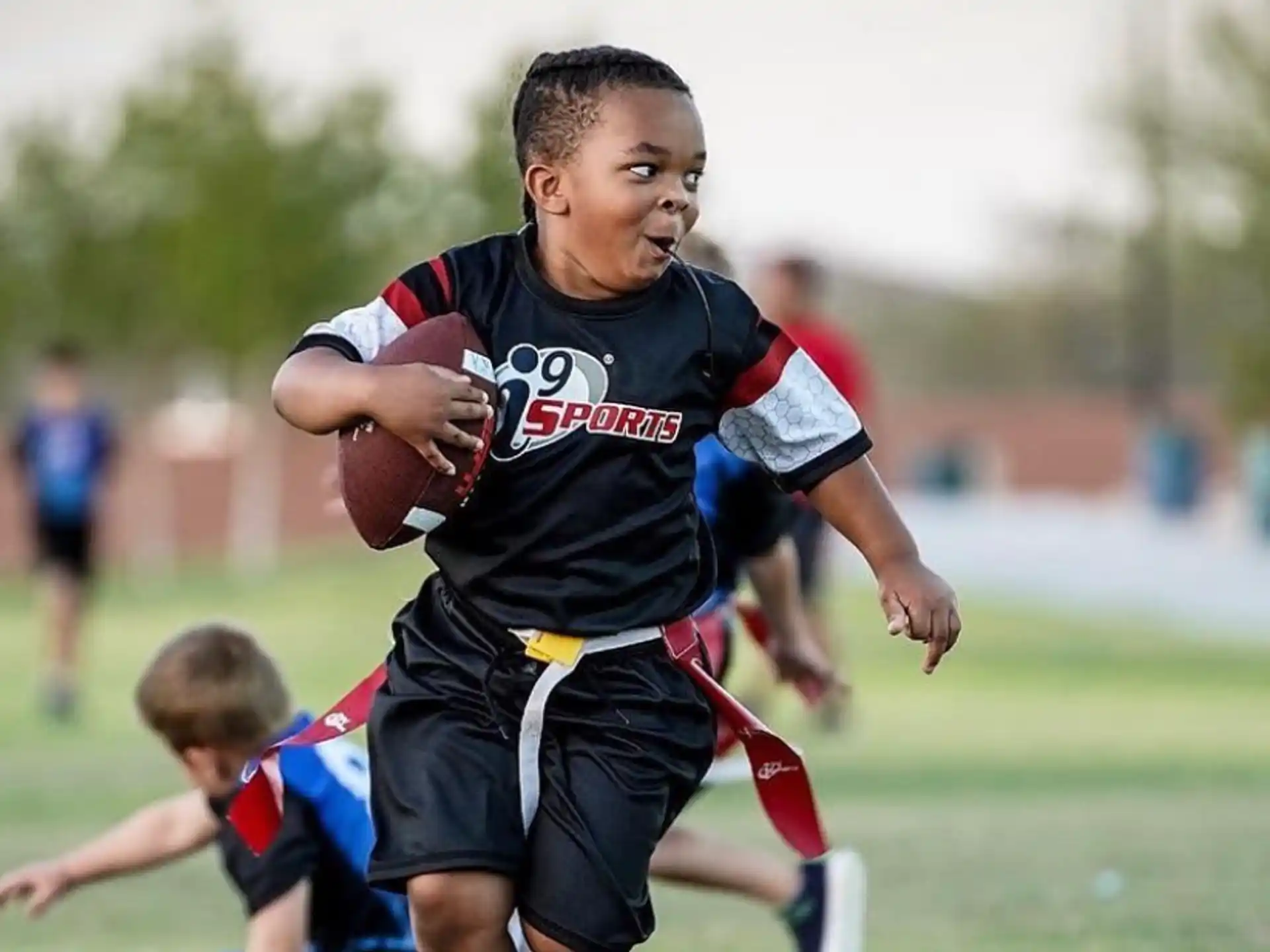 a boy running with a ball