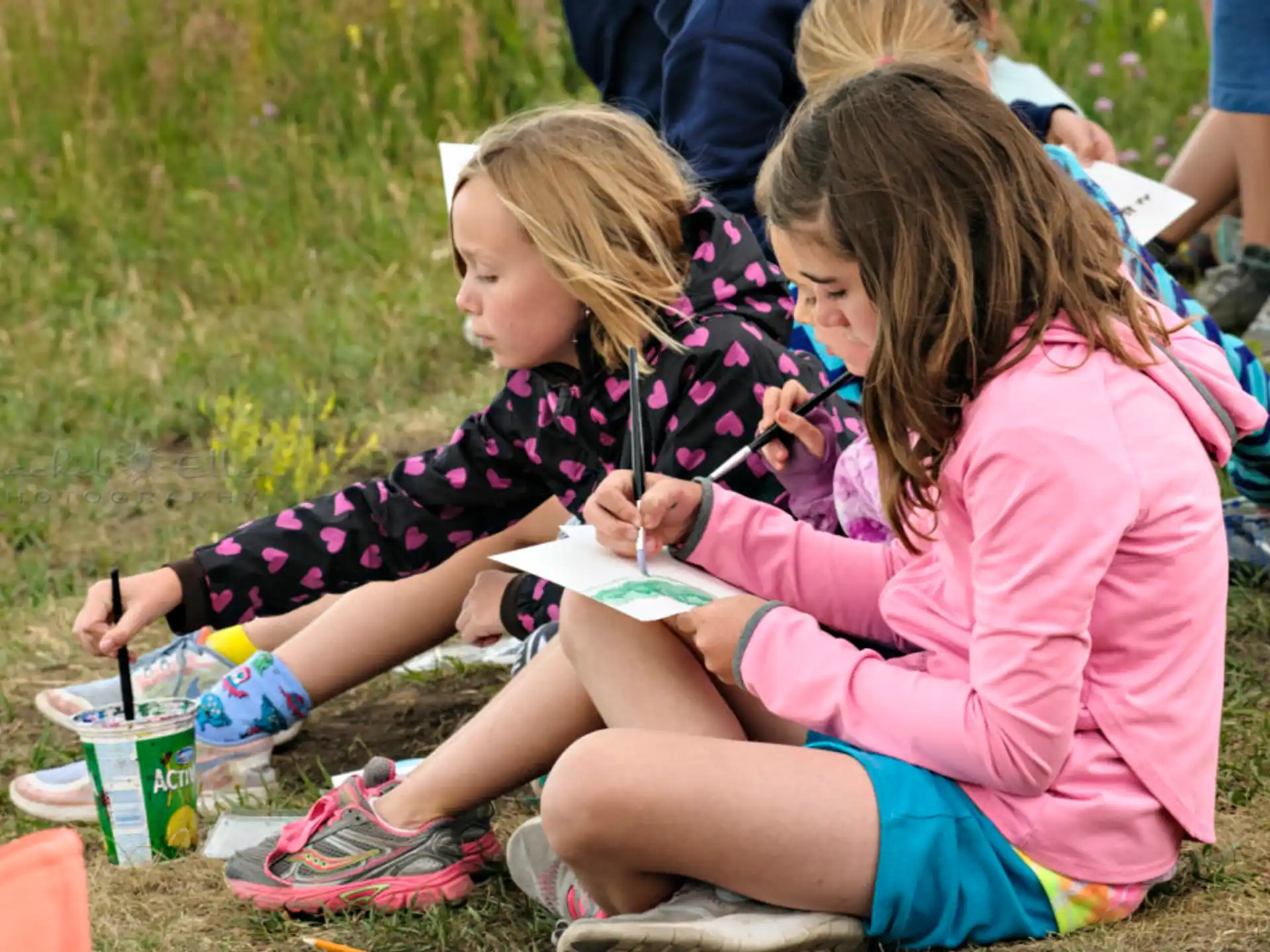a couple of girls sitting on the ground