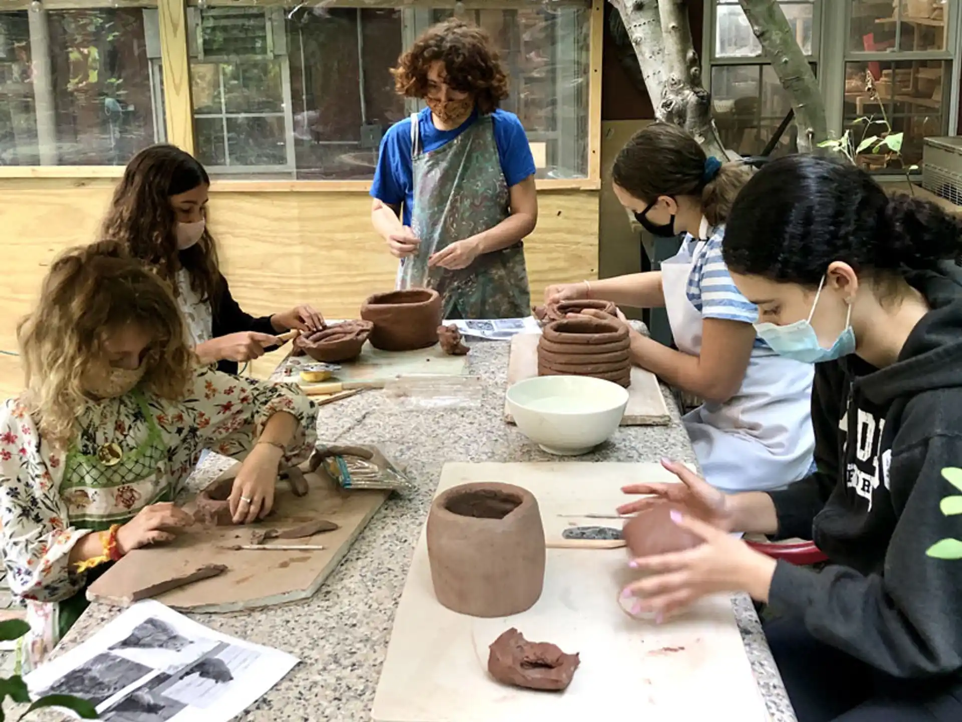 a group of people working on pottery