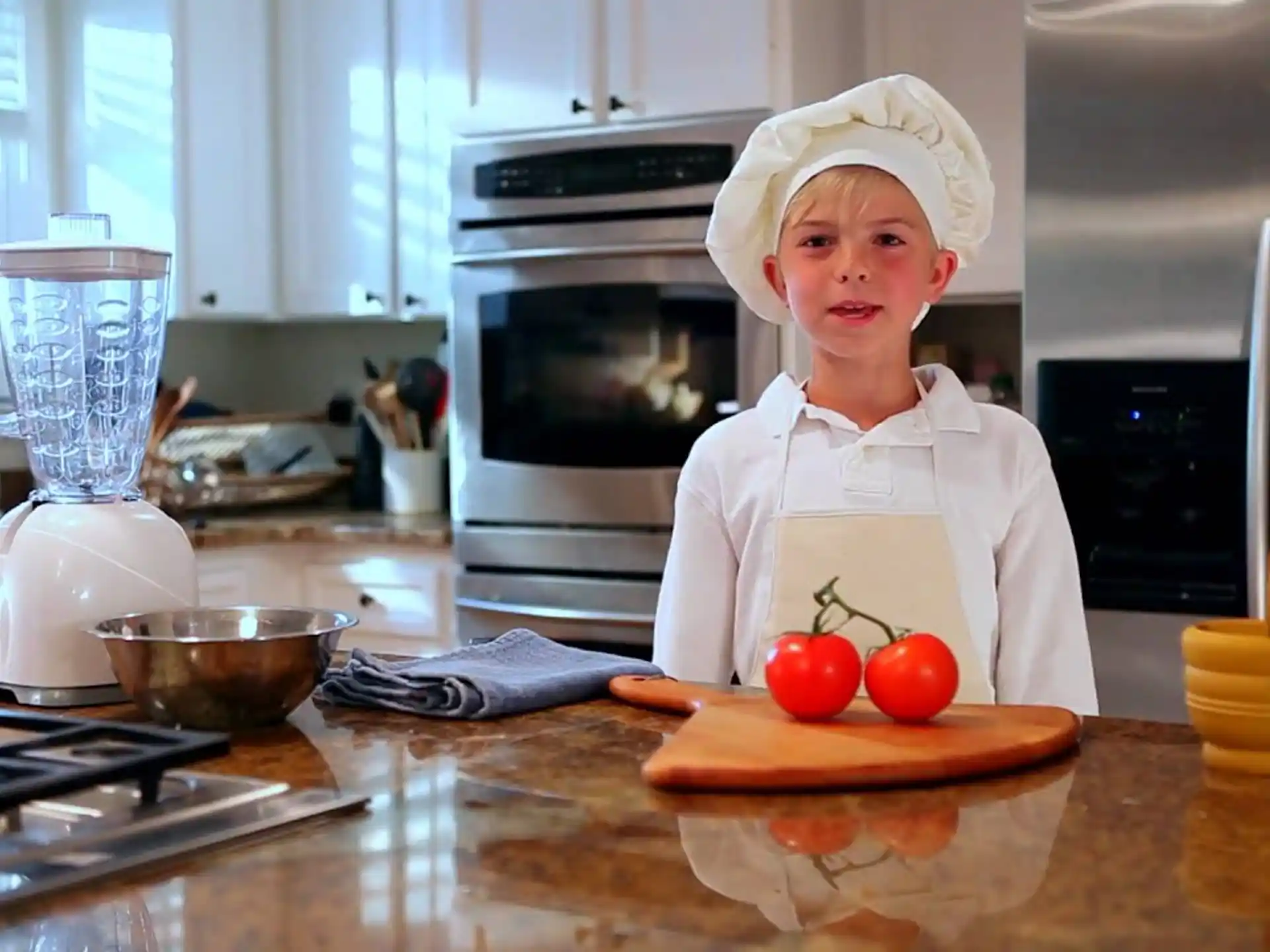 a boy in a chef's hat in a kitchen
