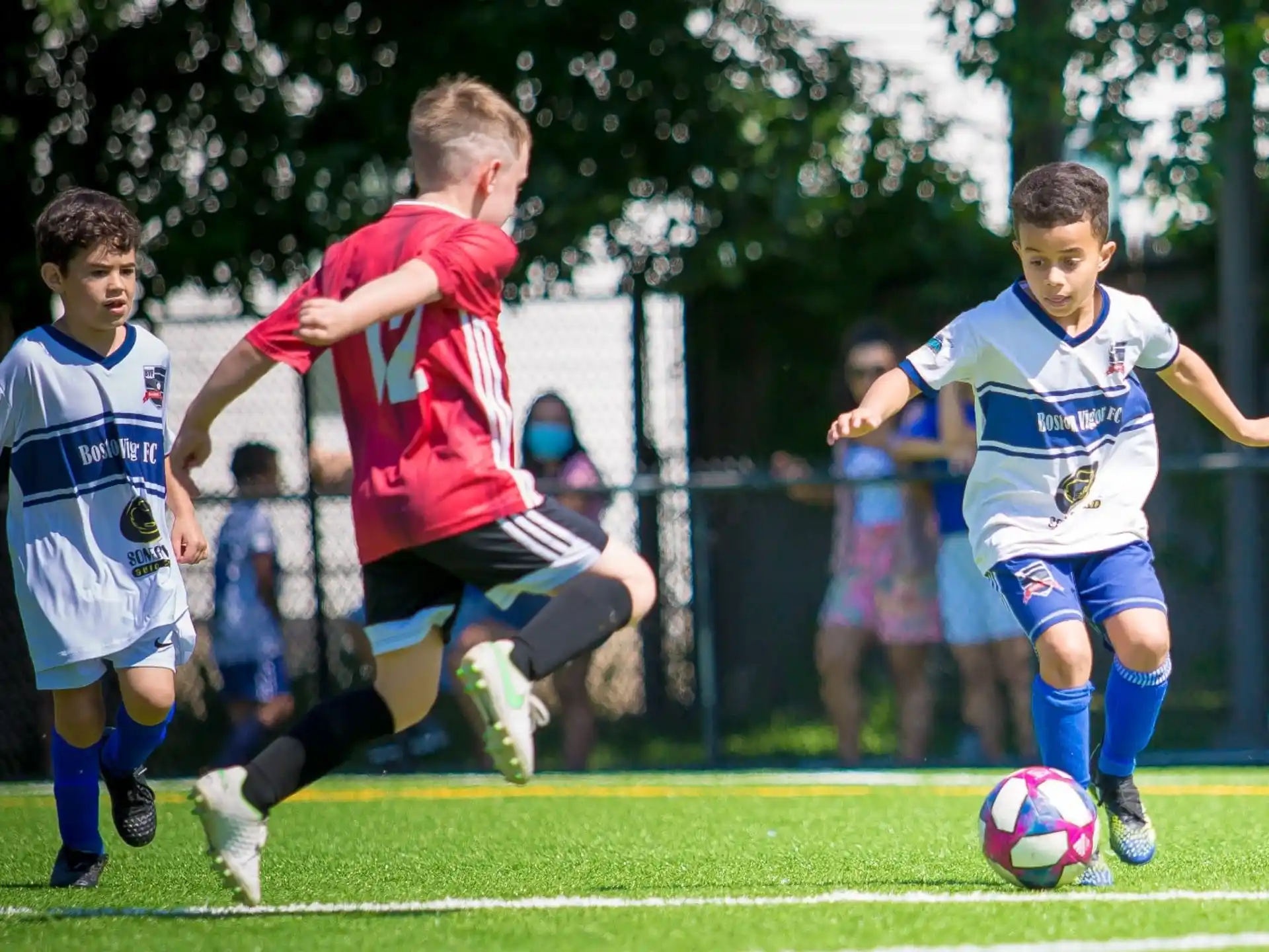 a group of kids compete over a football ball