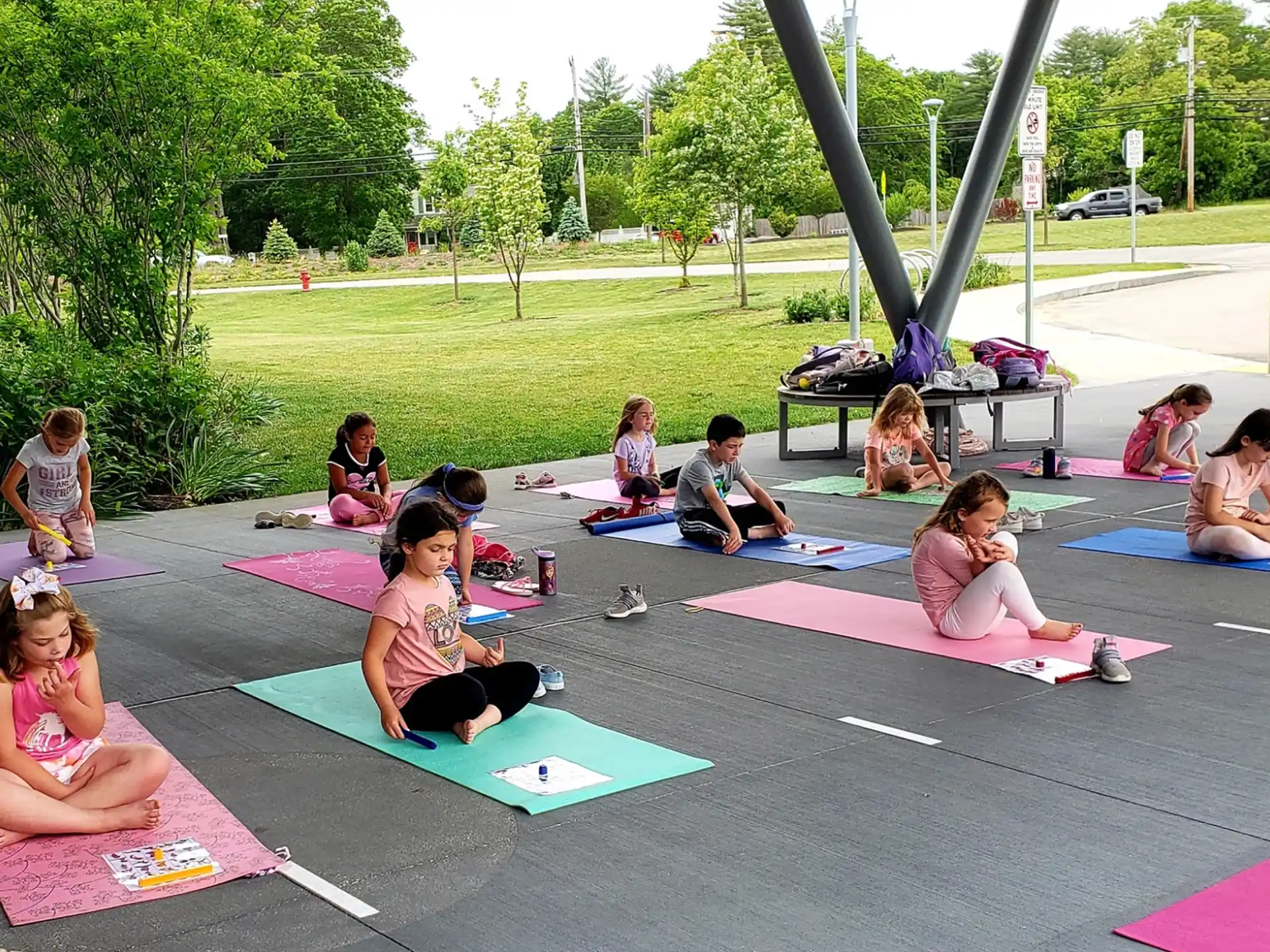 a group of people sitting on mats outside